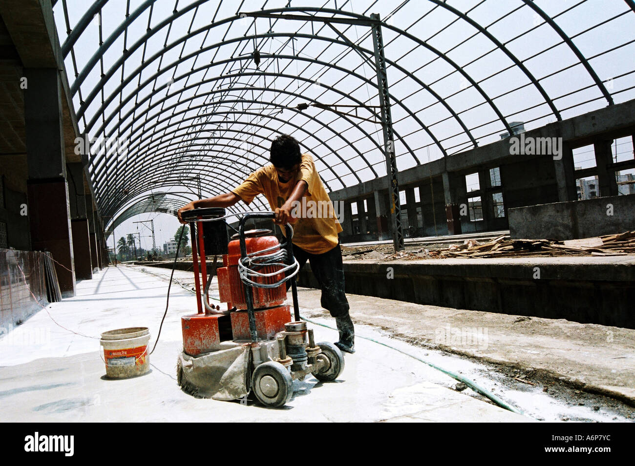 Indian worker polishing marble natural stone tiles during the construction of Kharghar Railway