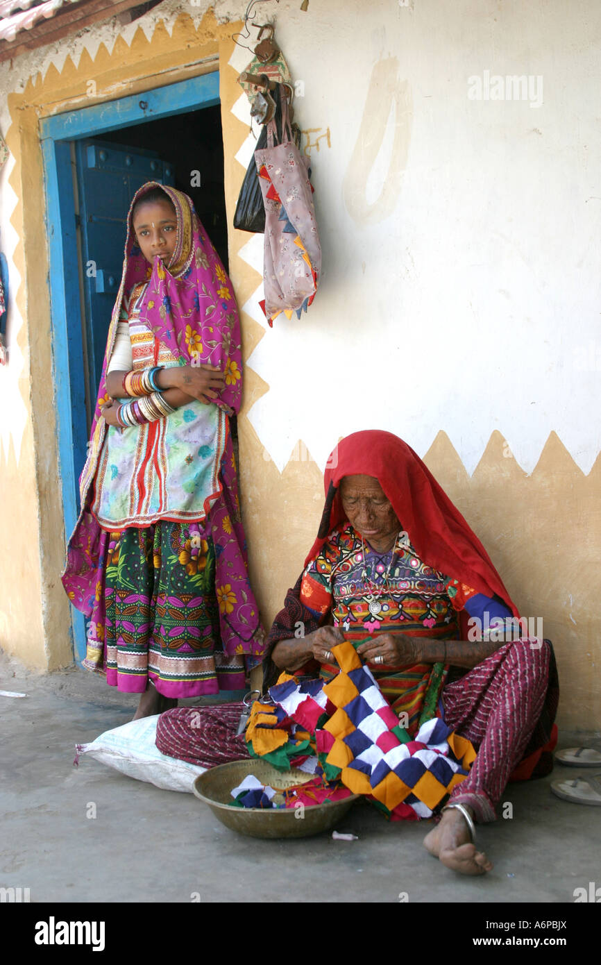Banni tribal grandmother sitting in doorway with her daughter standing in the doorway of her house in Gujarat India Stock Photo