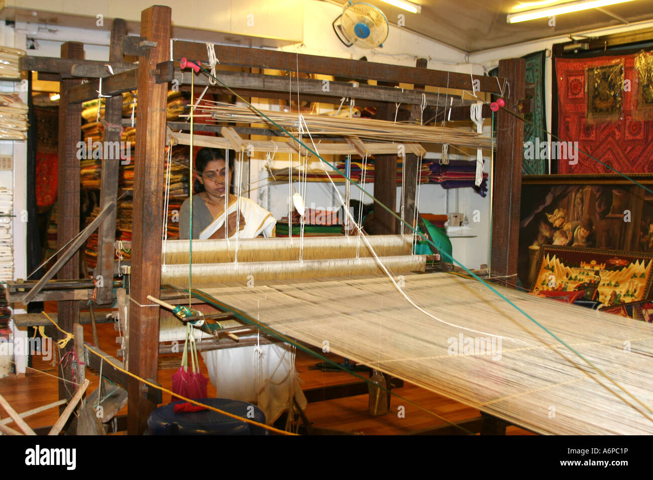 Indian woman using a wooden mechanical loom to weav e in Jew Town ,Cochin,India Stock Photo