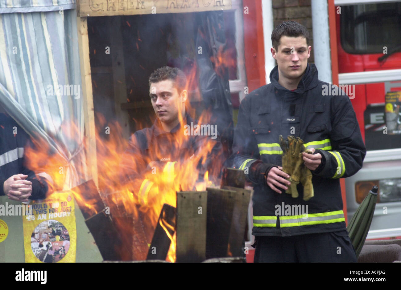A young contingent of the Bletchley fire service huddle round a brazier UK Stock Photo