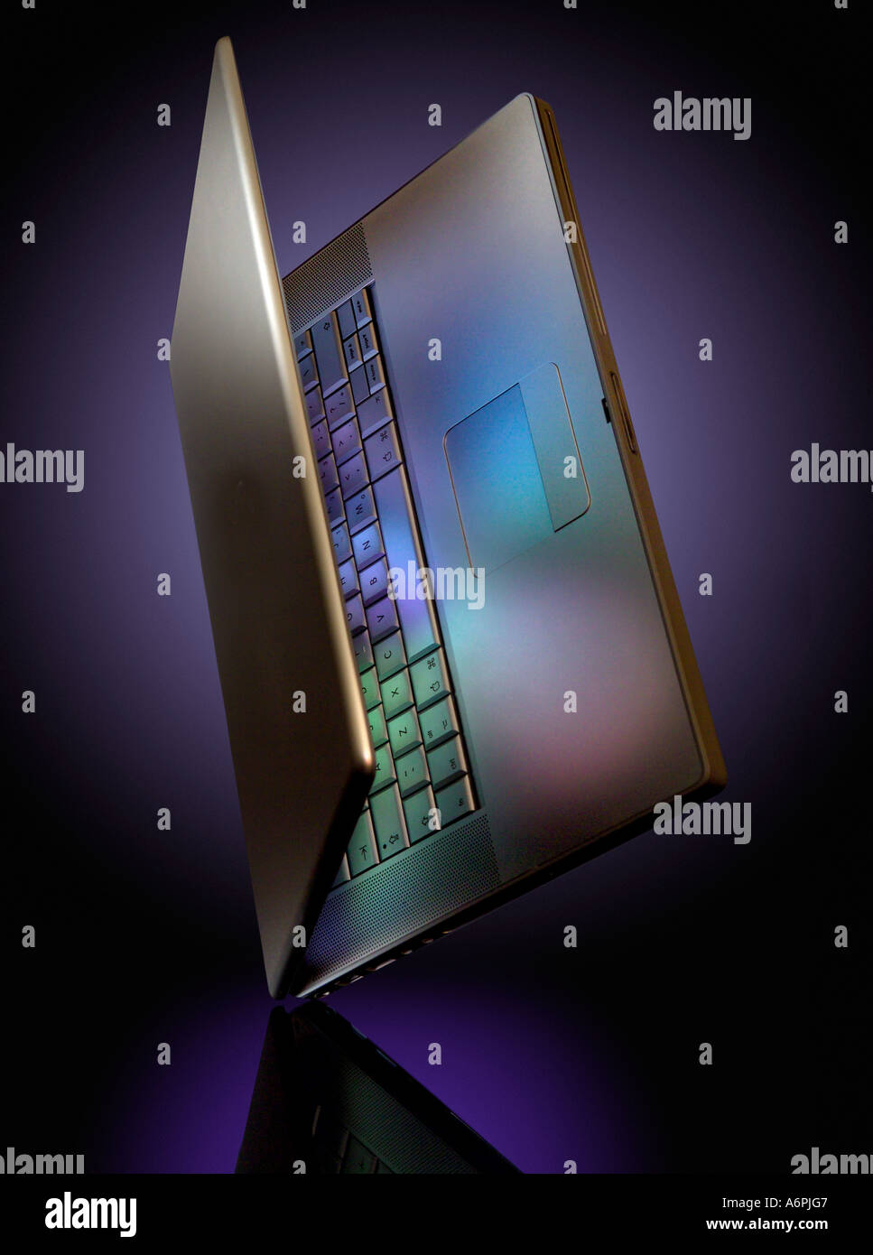 A LAPTOP BALANCING ON ITS CORNER WITH COLOURED REFLECTIONS Stock Photo