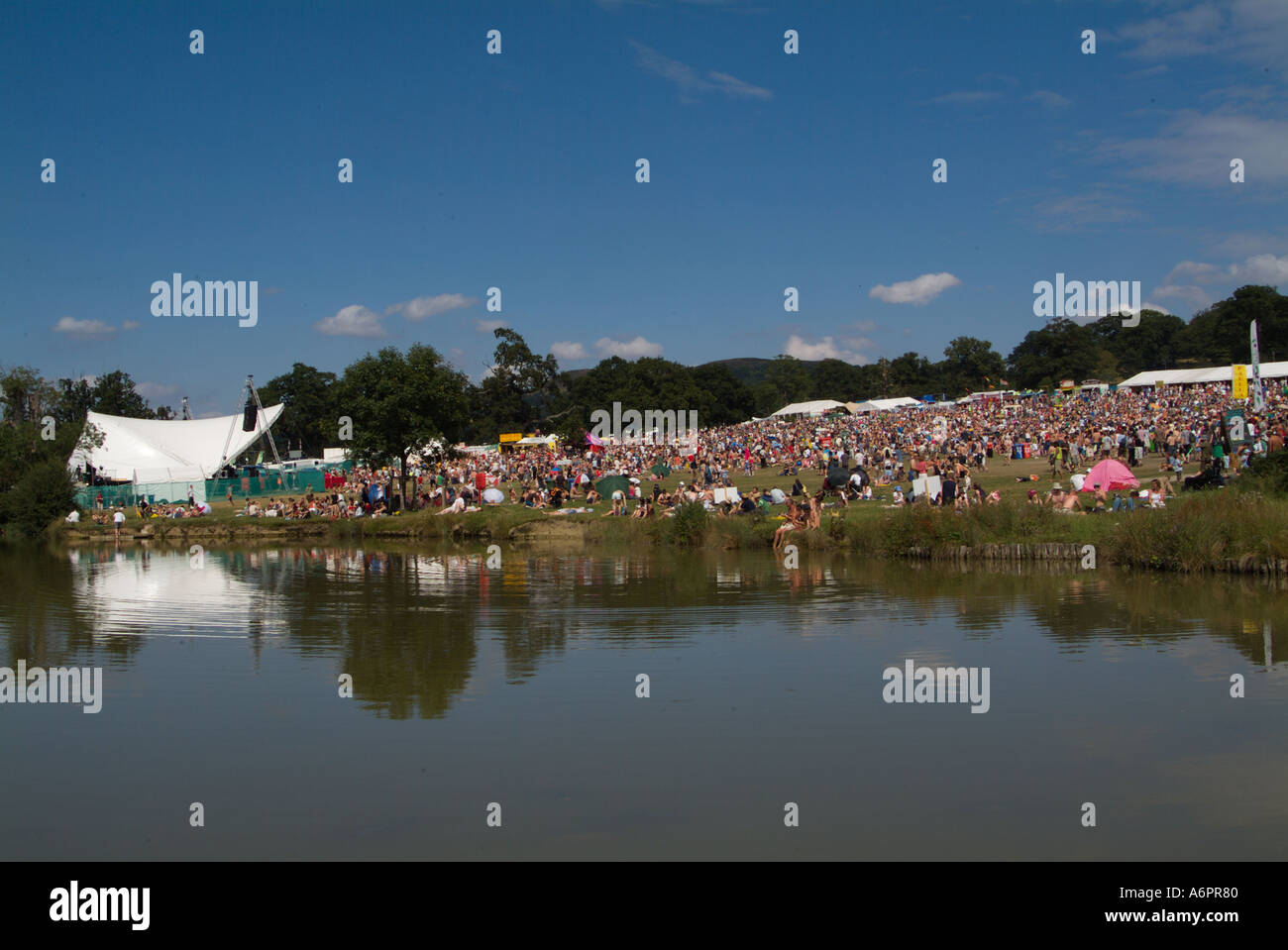 Crowds of party goers reflected in the lake at the Big Chill music and dance festival Stock Photo