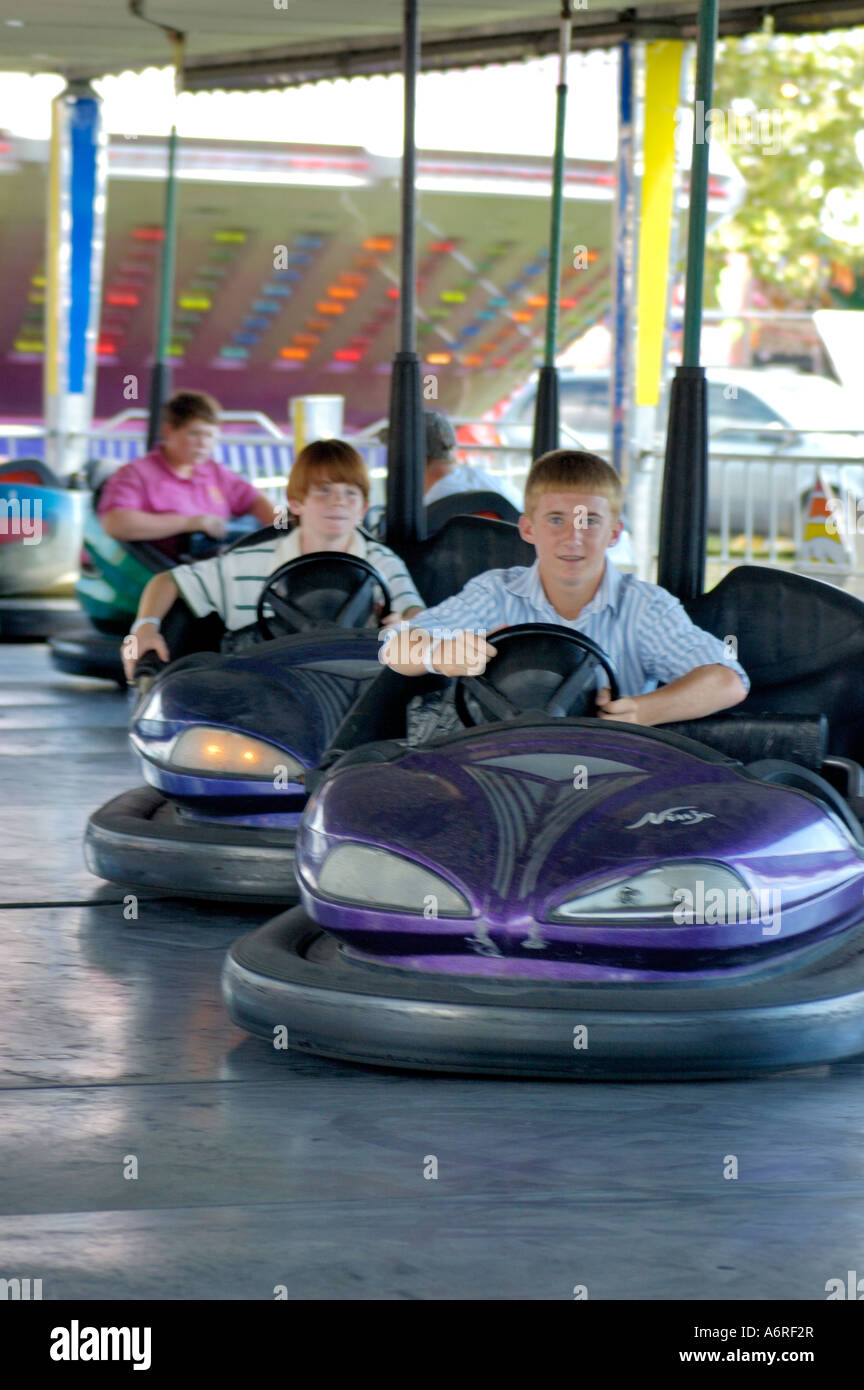 Teenage boys having fun on a bumper car ride at the amusement park ...