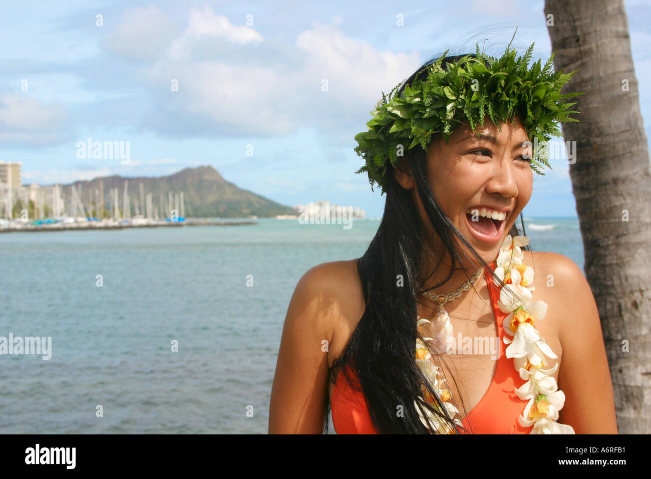 Young Hawaiian woman with lei smiles with Diamond head crater in backround honolulu waikiki oahu hawaii Stock Photo