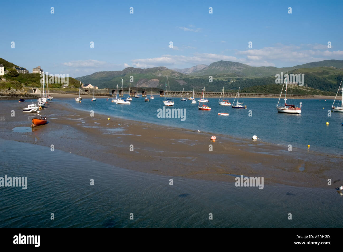 landscape of river estuary at low tide on bright sunny day with yachts at moorings Stock Photo