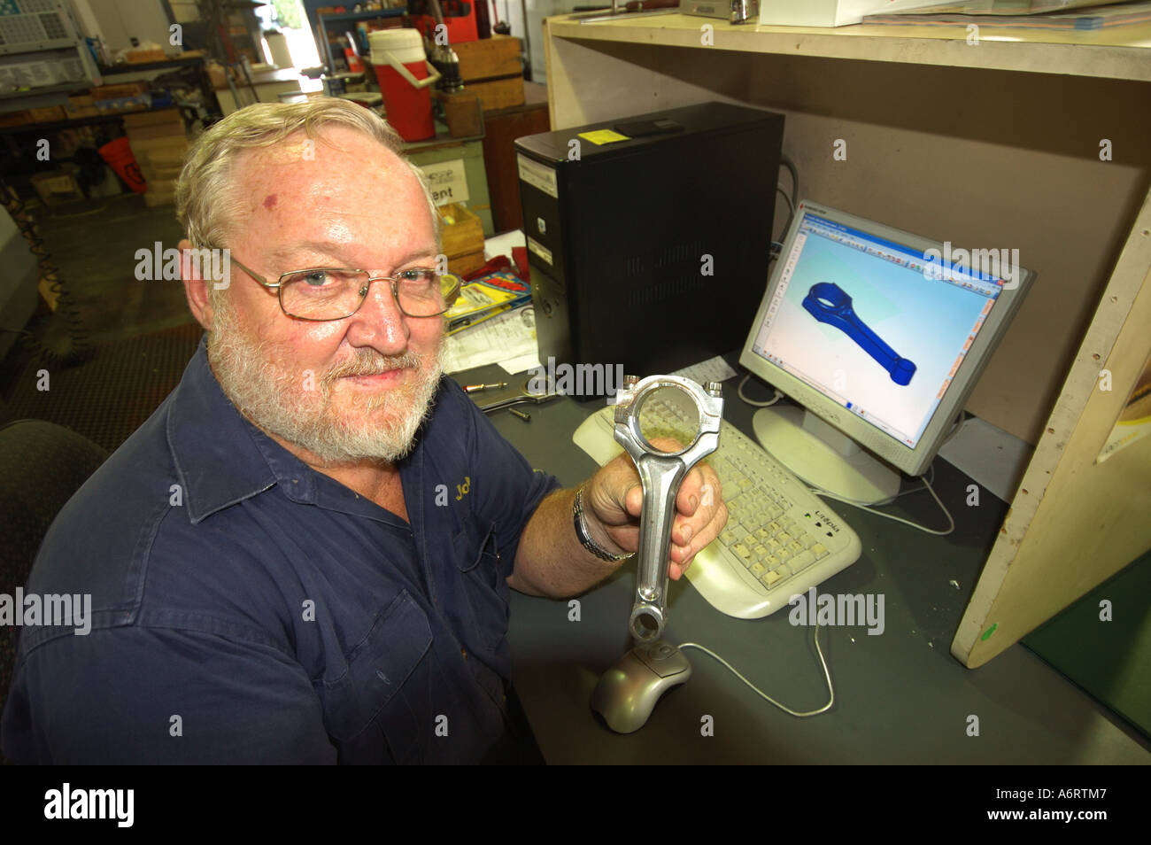 mature worker with CAD computer aided design piston cam shaft in metal workshop Stock Photo