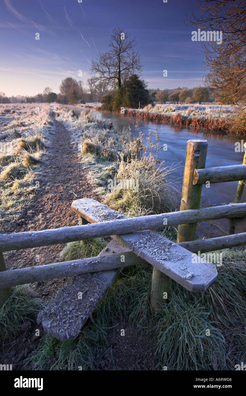 A stile and footpath beside the river Itchen near Winchester on a cold frosty winters morning Stock Photo