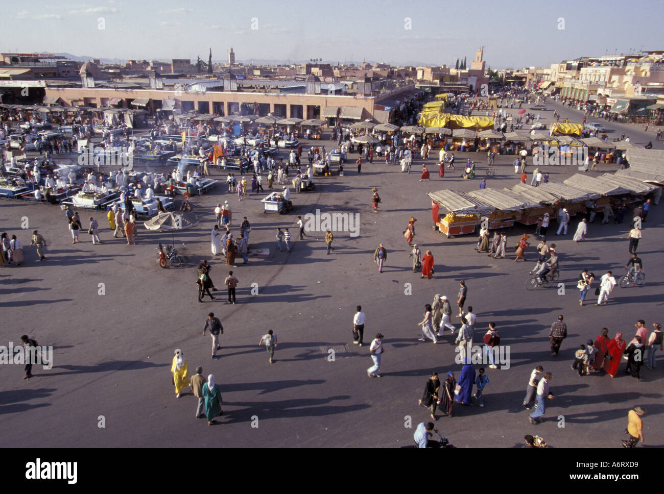 Africa, Morocco, Marrakesh, Crowd near orange juice stalls, musicians, and shops in huge square, Djemaa el-Fna Stock Photo