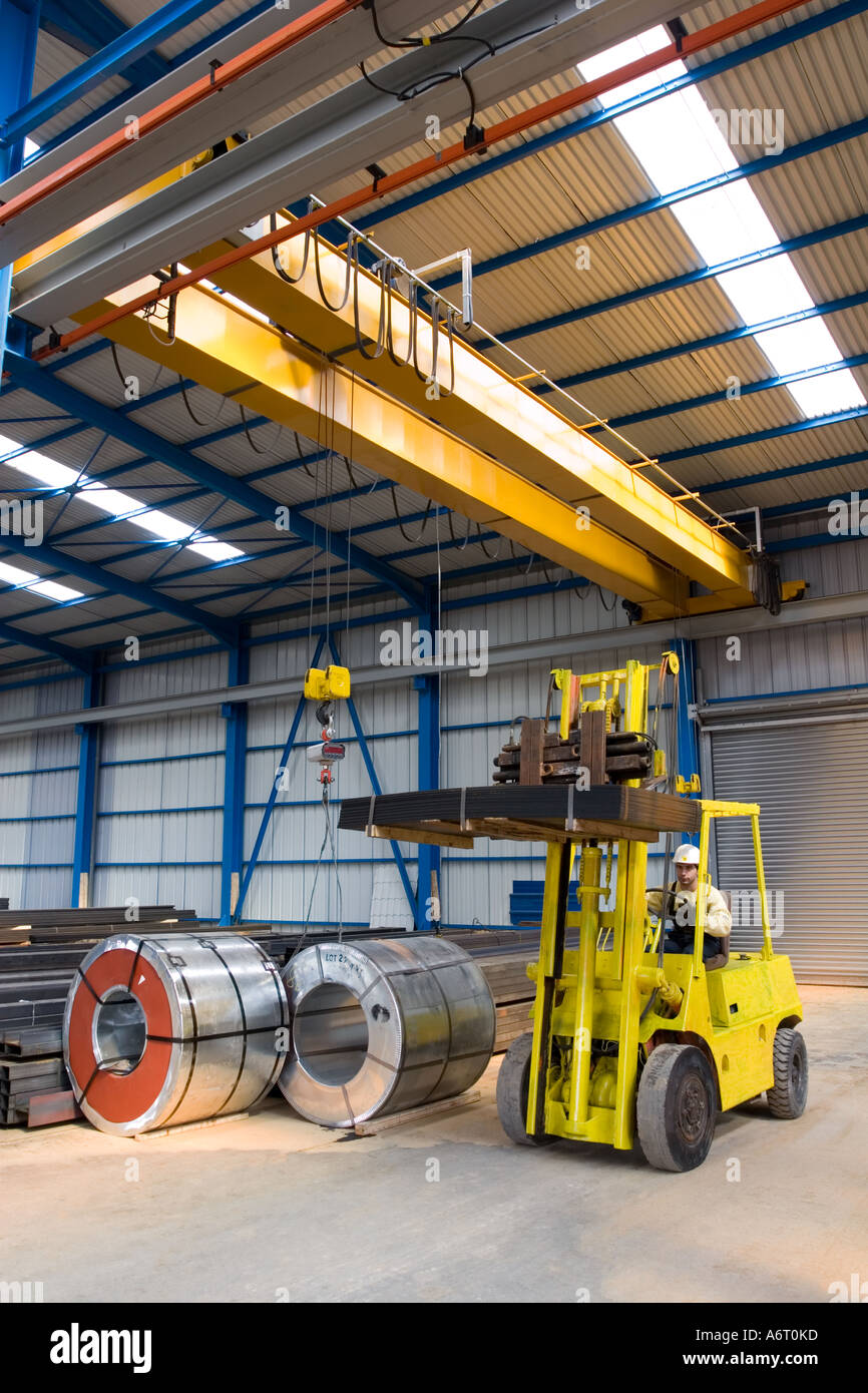 Cargo lifting vehicle in warehouse, industrial environment. Driver is