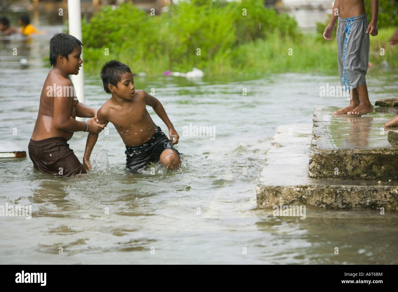 Tuvaluan children escape the rising flood waters on Funafuti Stock Photo