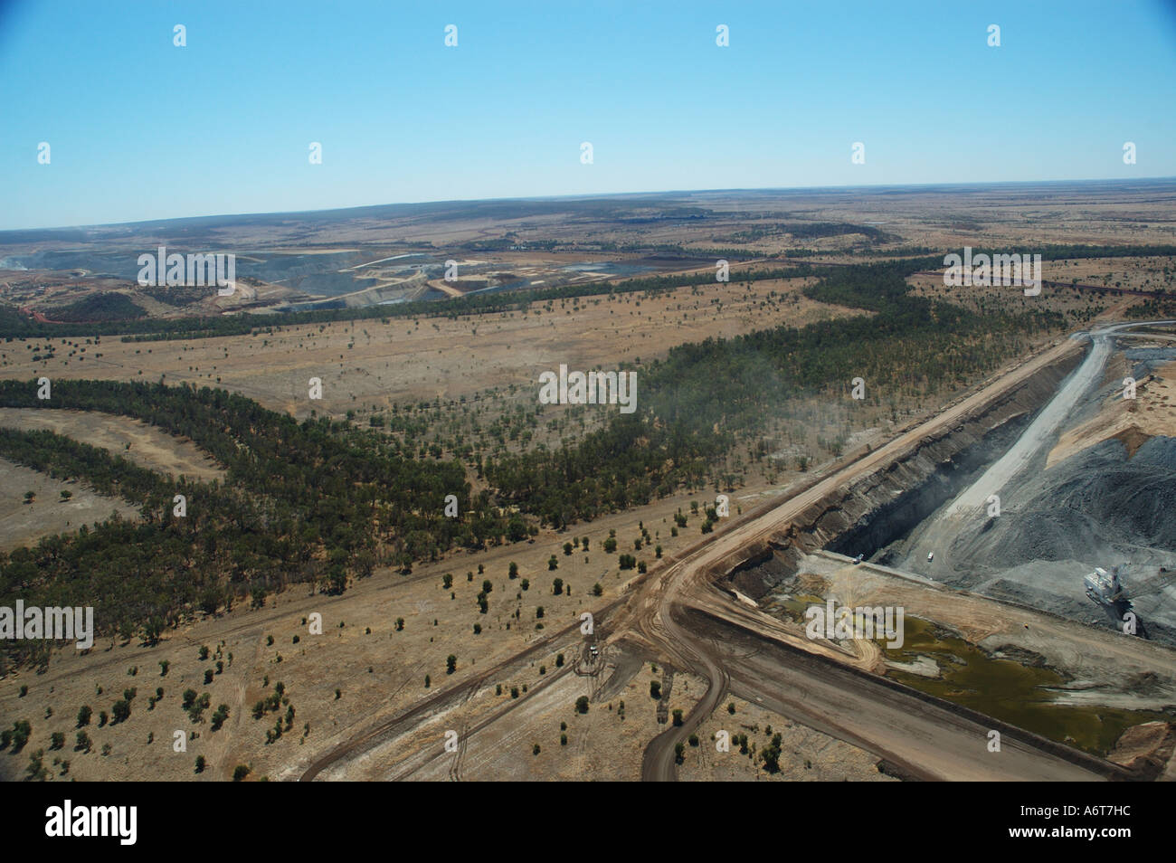 Outback river runs past open cut coal mine Central Queensland coal basin Australia Stock Photo
