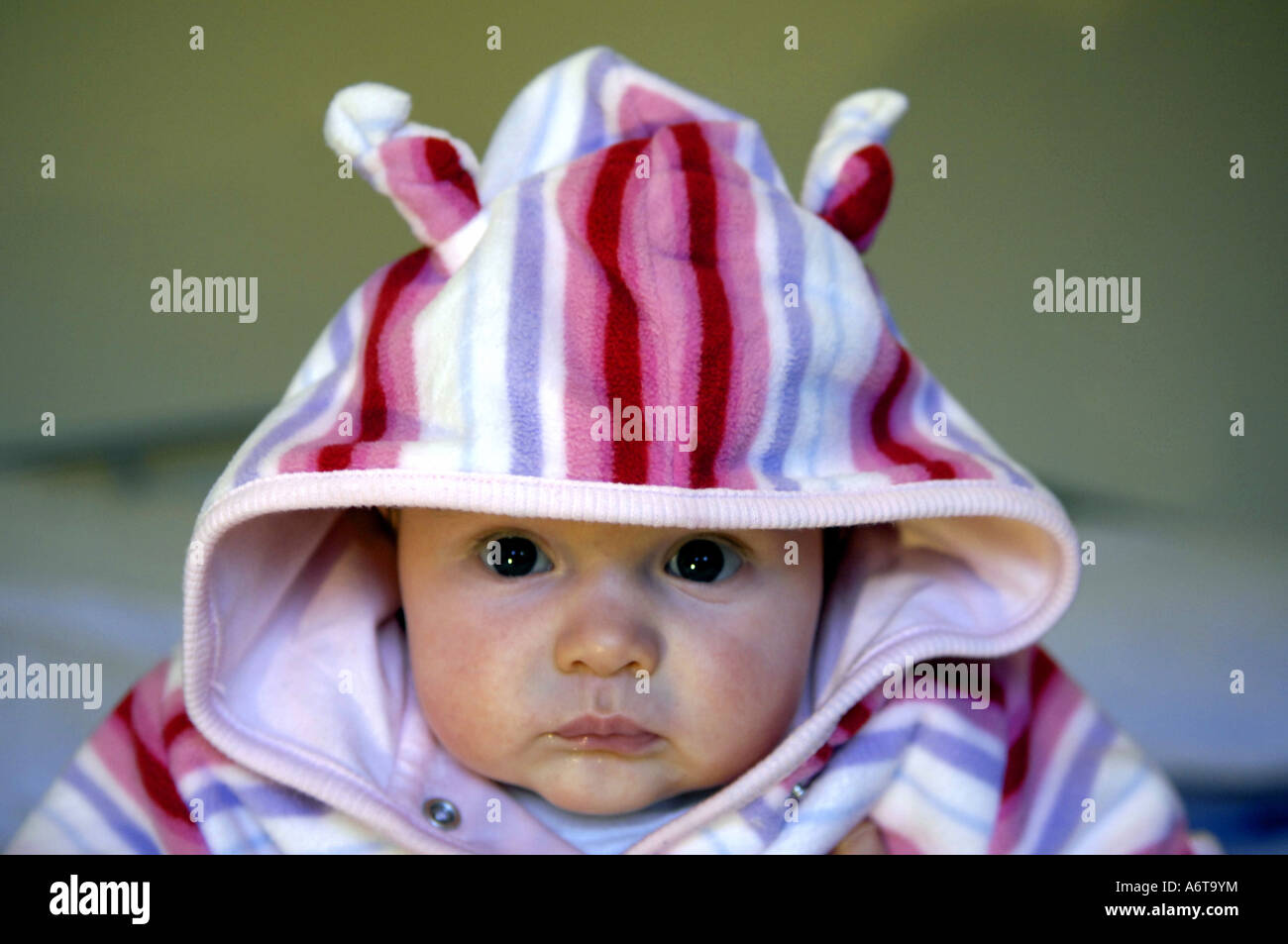 baby girl three months old caucasian colour color face head hoodie hoody clothing stripes stripey stripy horizontal portrait Stock Photo