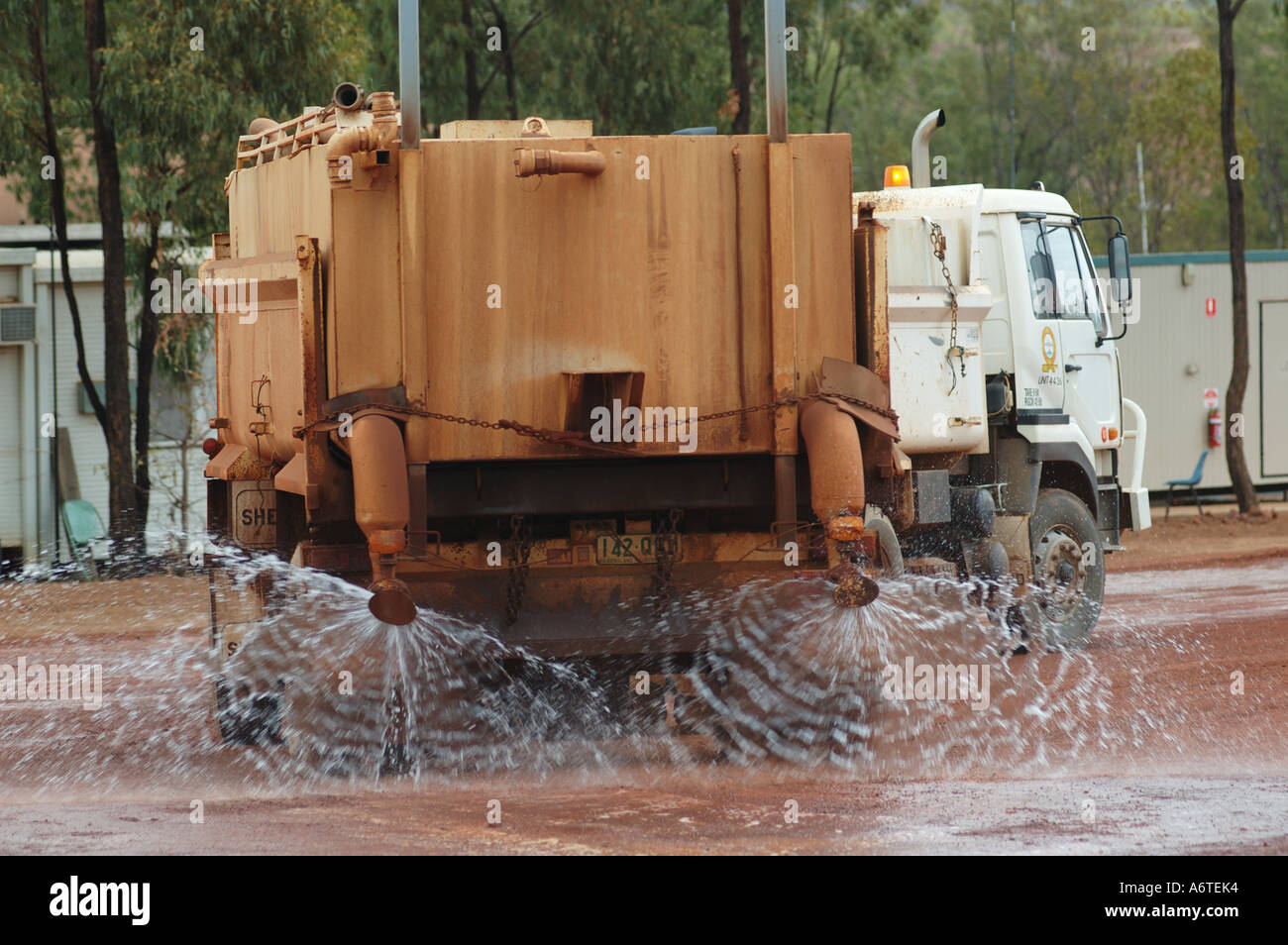 Water tanker suppresses red dust and earth at mine site Stock Photo - Alamy