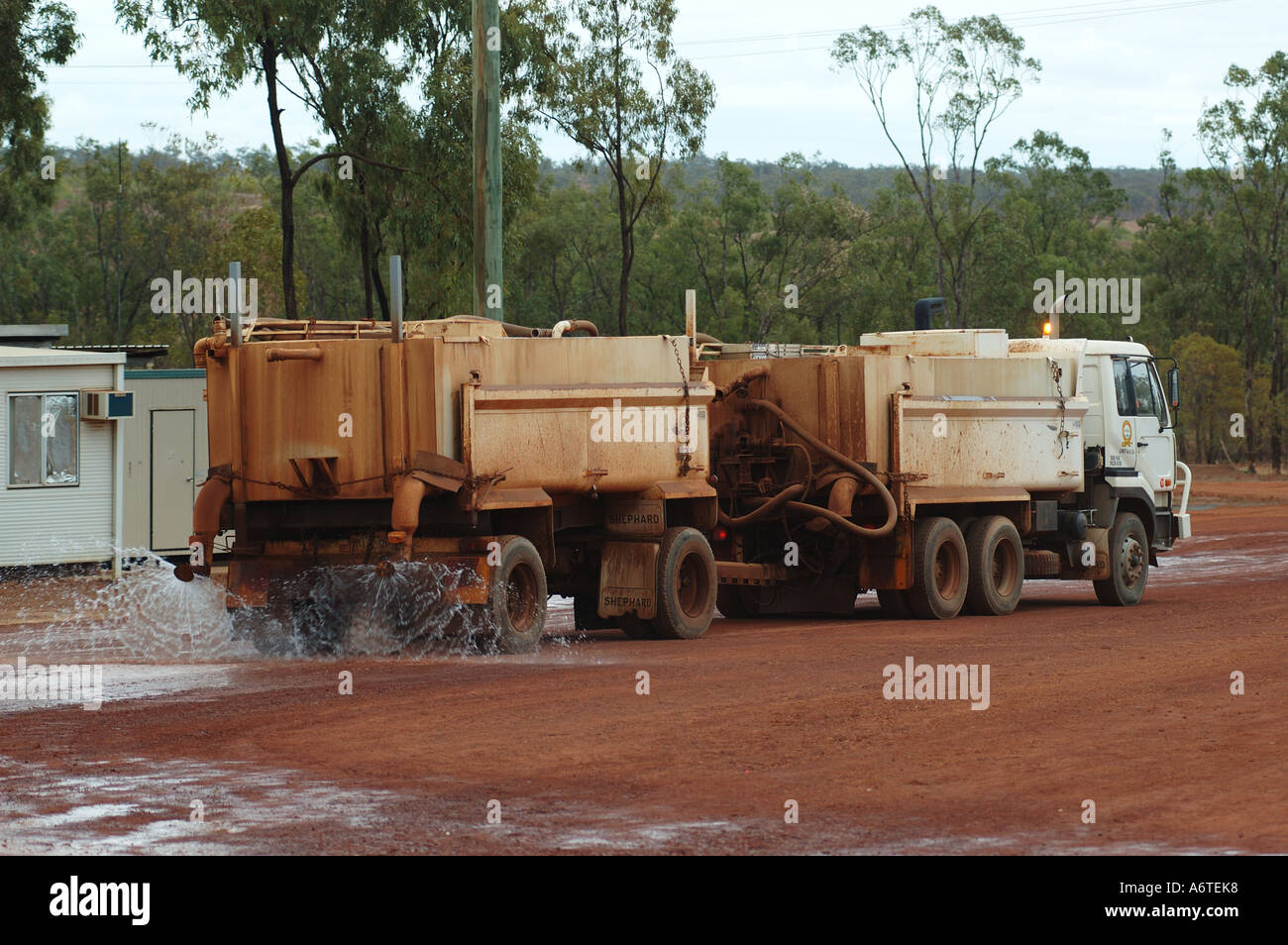 Water tanker suppresses red dust and earth at mine site Stock Photo - Alamy
