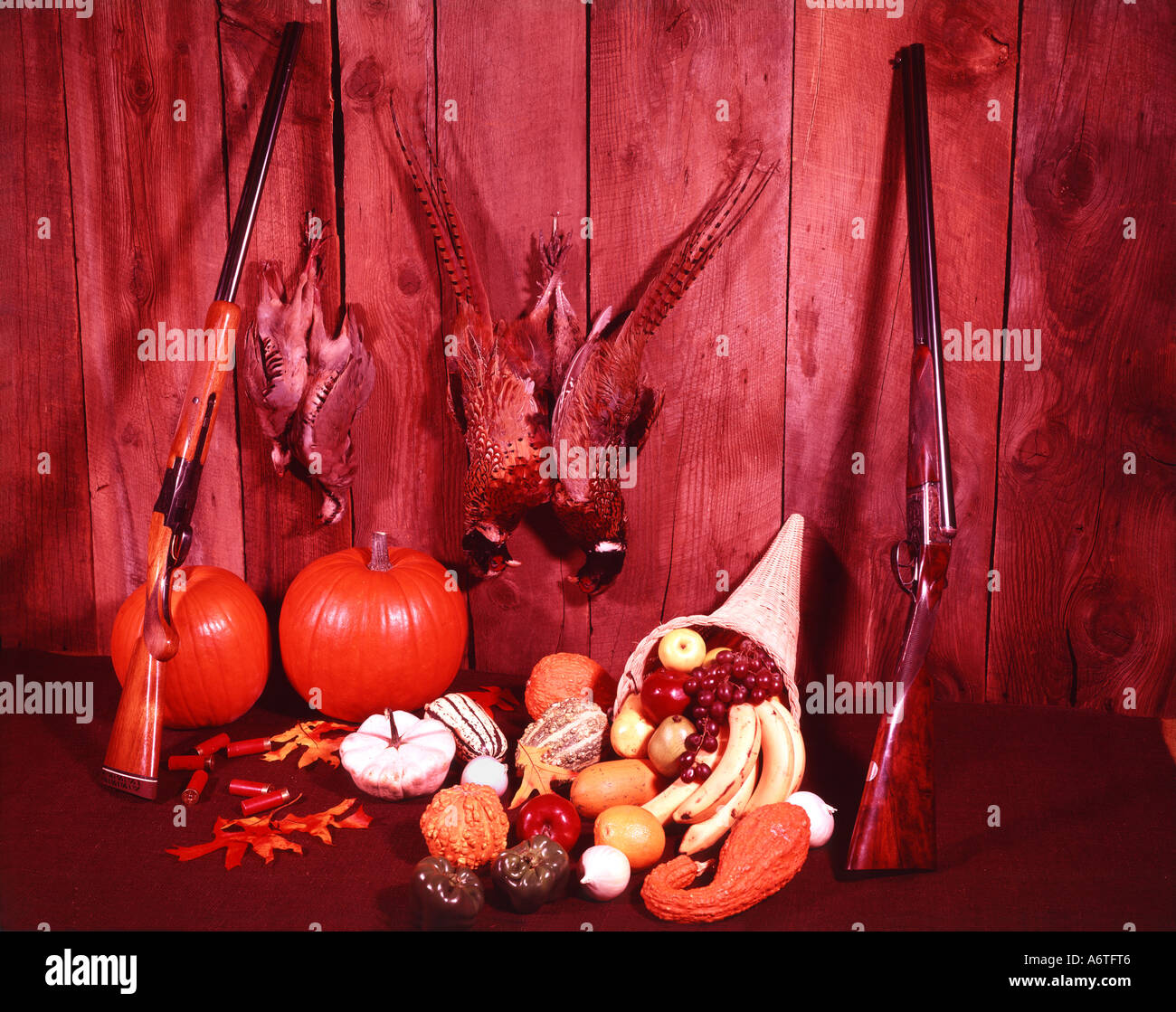 Game birds hang from an old wood background in a Autumnal still life