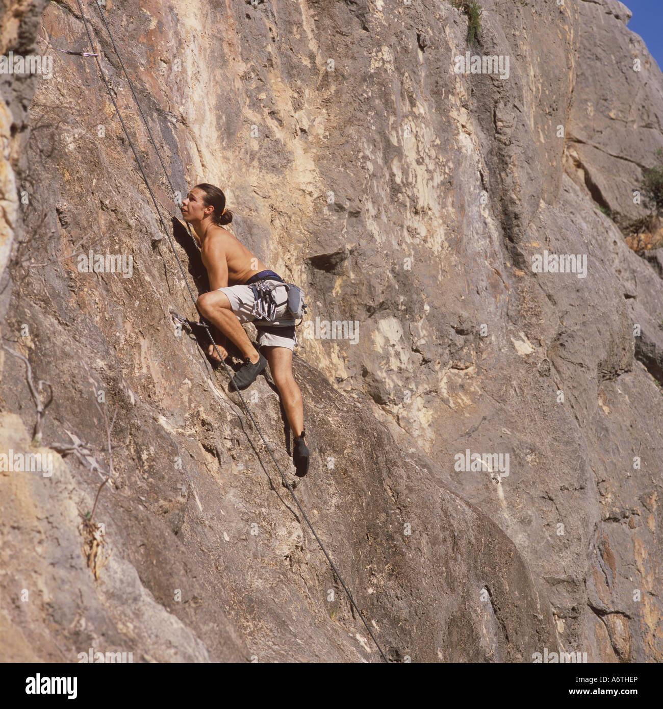 Rock climber ascending a rock face in South West Mallorca, Balearic Islands, Spain. 8th October 2005. Stock Photo