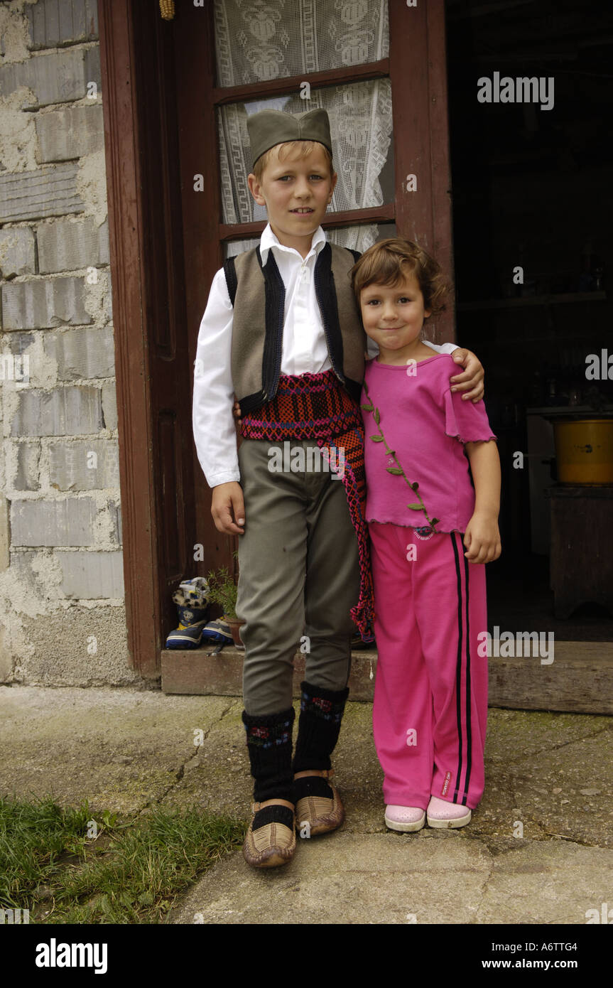 a boy in serbian traditional costume holding his sister Stock Photo