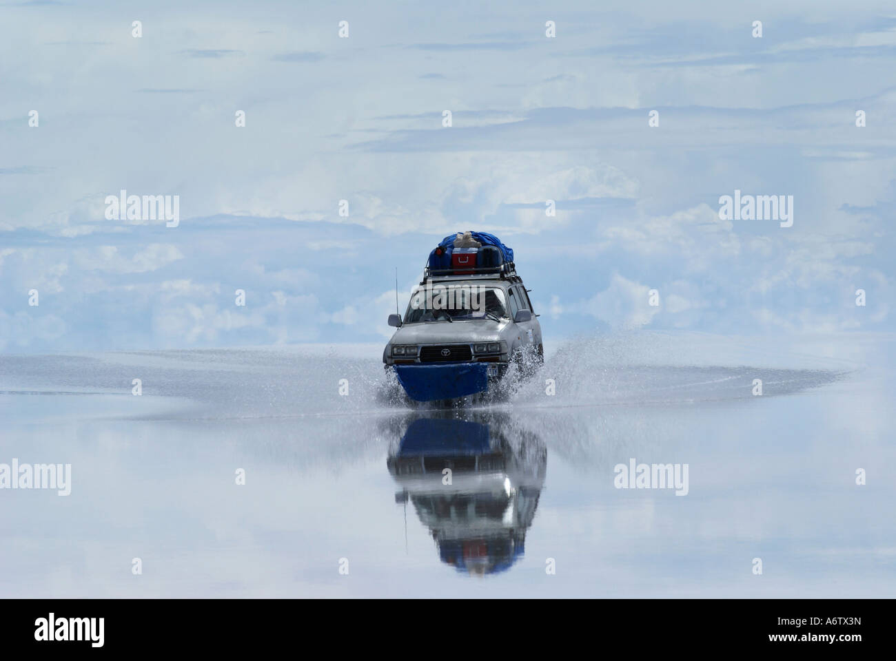 Four Wheel Drive driving through the flooded salt desert Salar de Uyuni, Bolivia Stock Photo