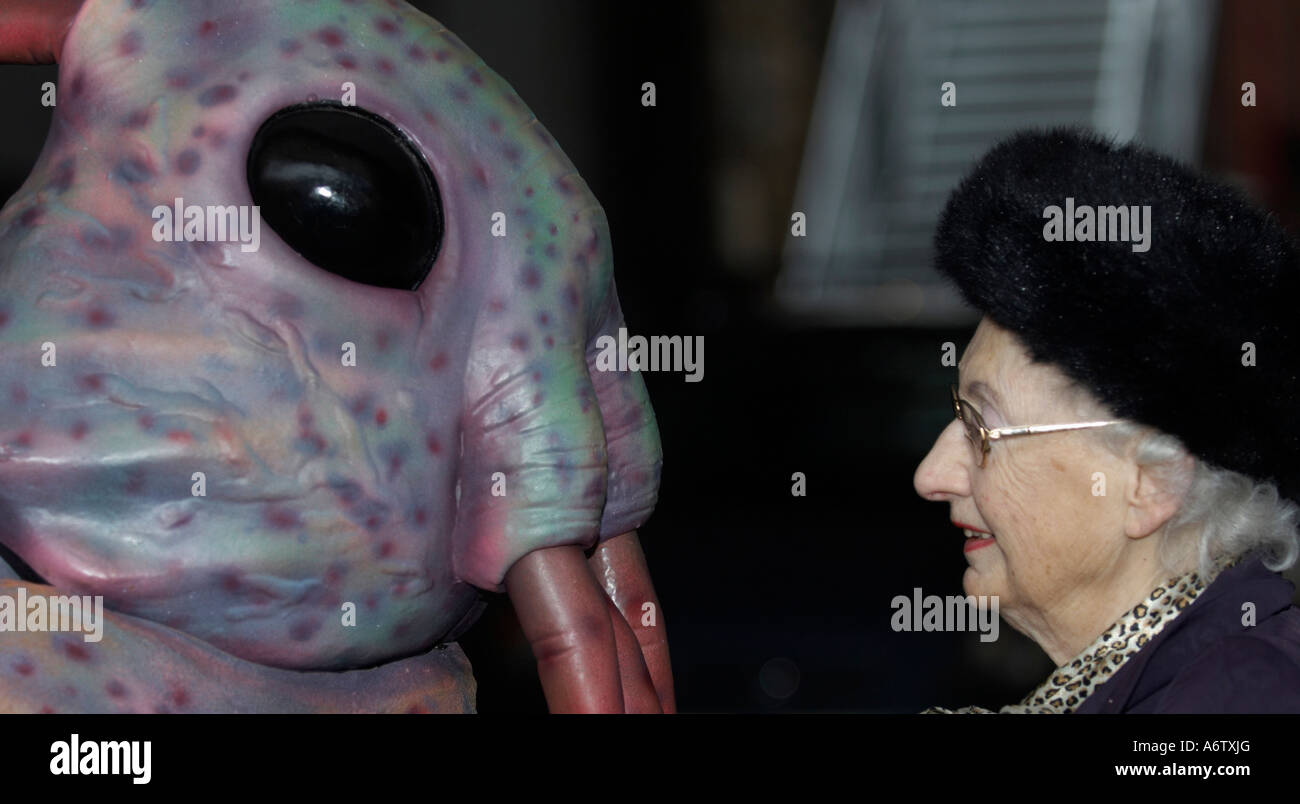 Elderly lady talking to an extraterrestrial monster Stock Photo