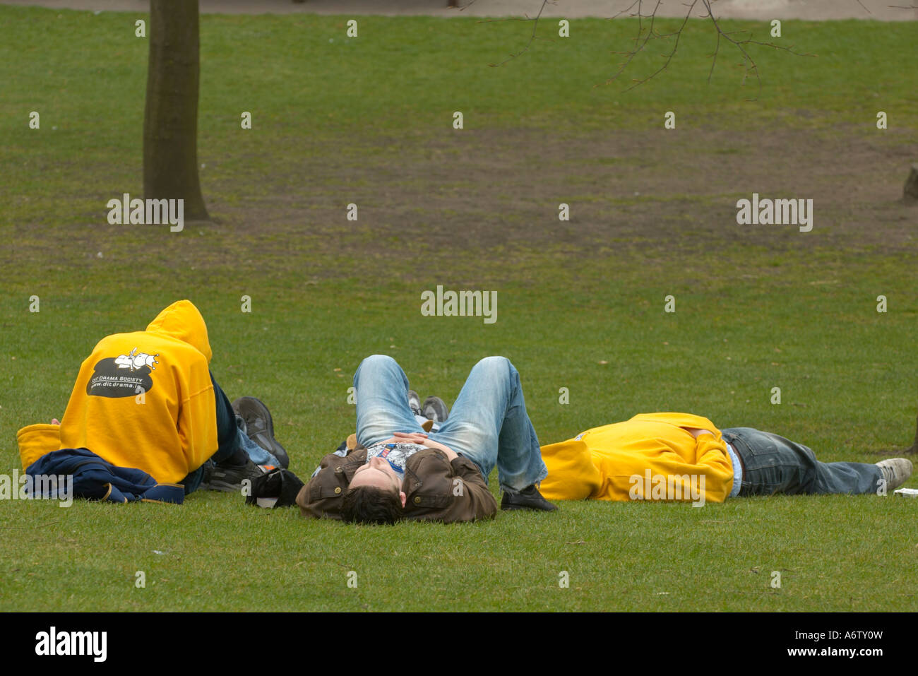 Teenagers laying on the lawn in a park Stock Photo