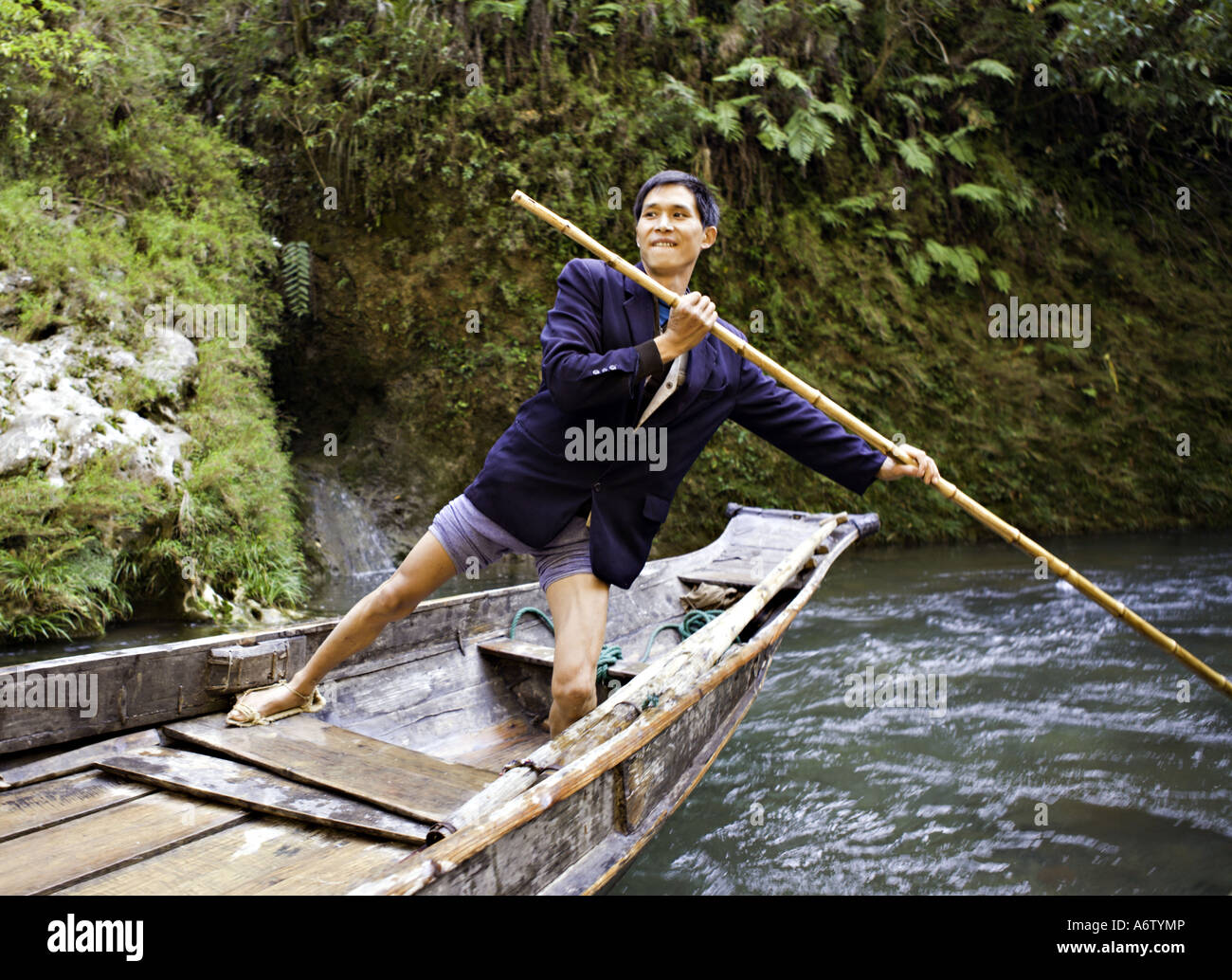 CHINA YANGTZE RIVER A peapod boatman strains against his bamboo pole to push  his peapod boat Stock Photo - Alamy
