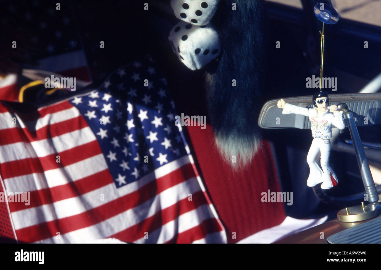 elvis doll hanging from rear view mirror with american flag in