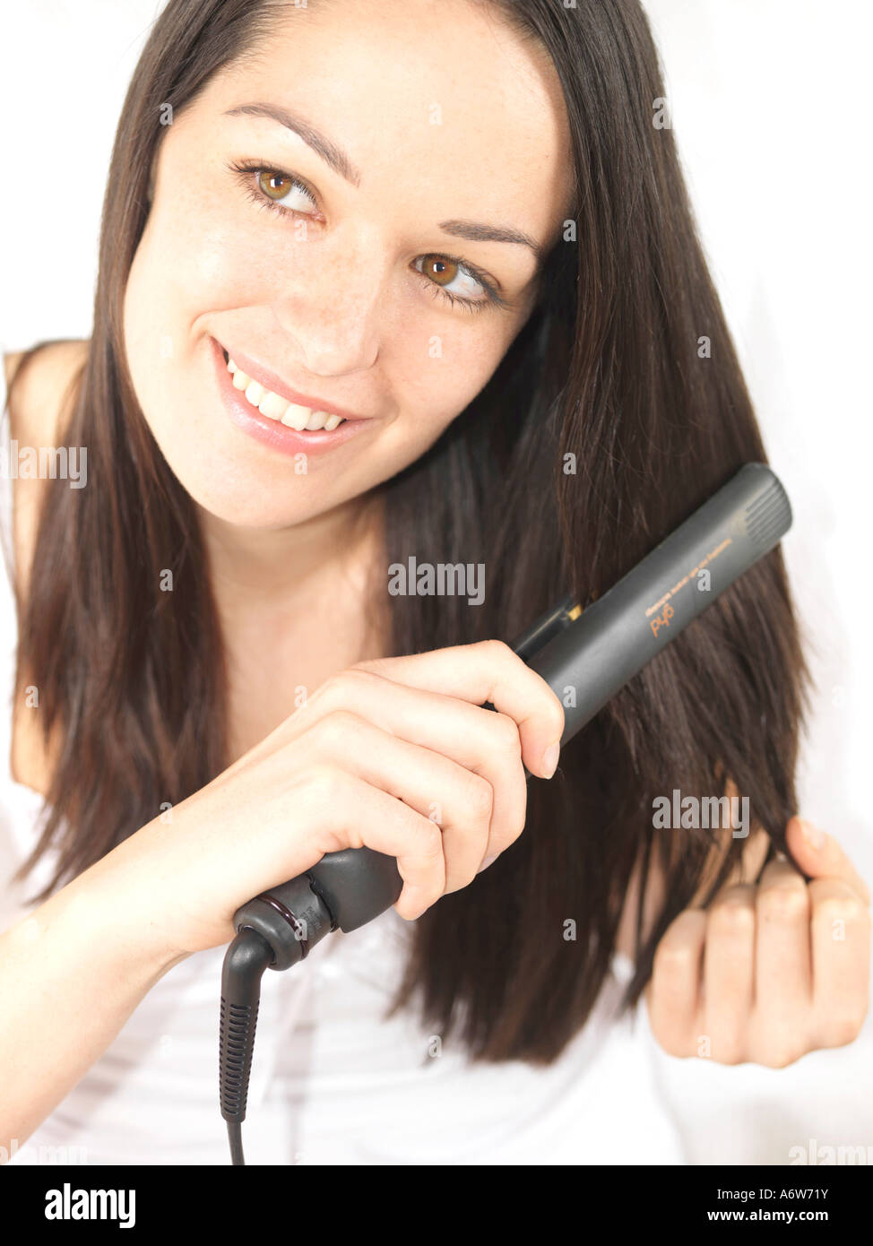 Young Woman Using Hair Straighteners Model Released Stock Photo