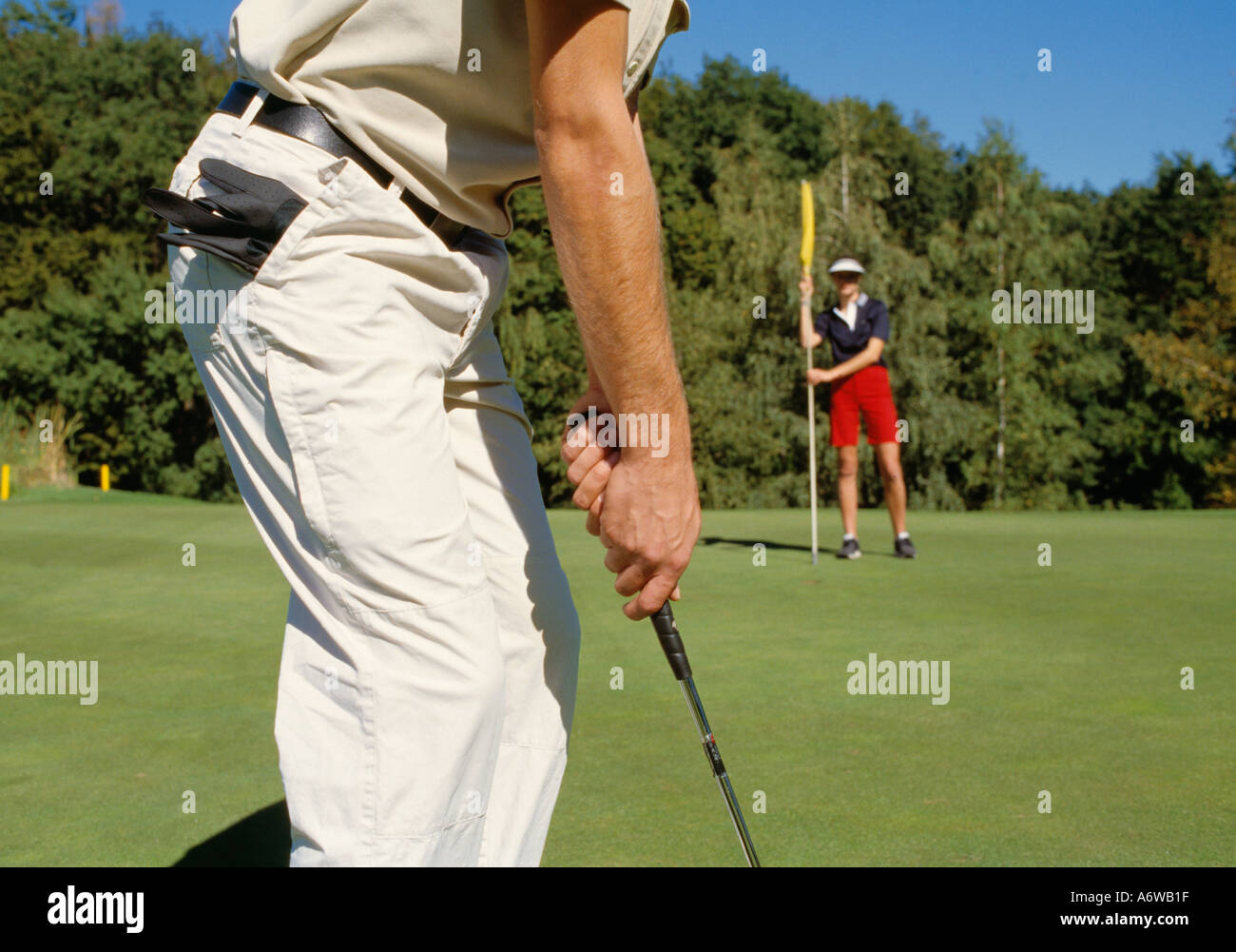Cropped shot of young male golfer lining up to hole Stock Photo