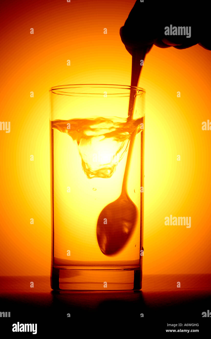 glass of drinking water being stirred by spoon Stock Photo Alamy