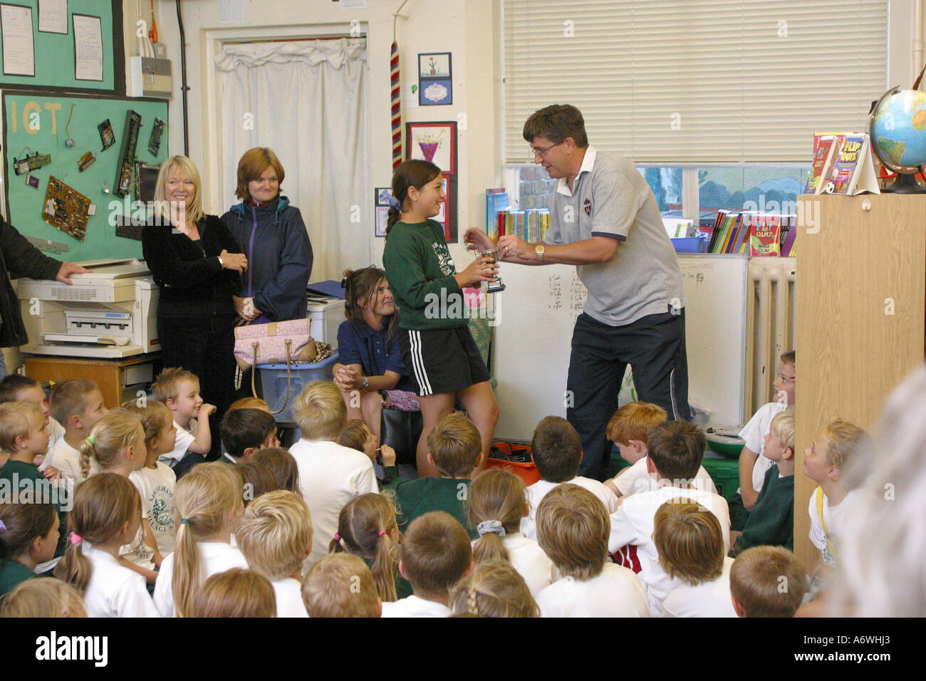 Teacher giving out awards on Sports Day at a primary school Stock Photo