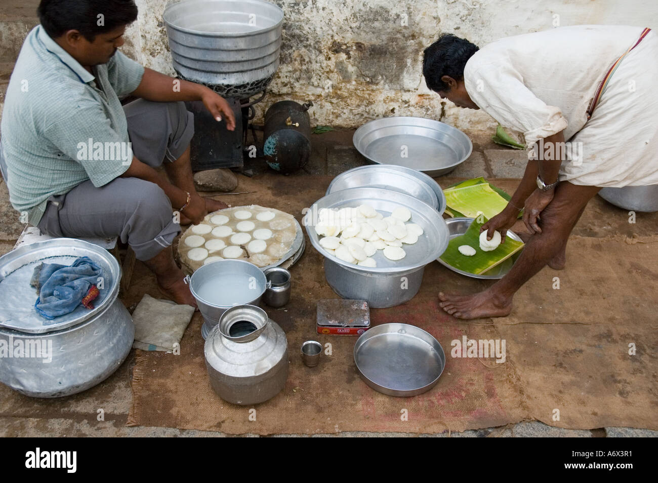 Men make rice dumplings known as Idli in the morning in India Stock Photo