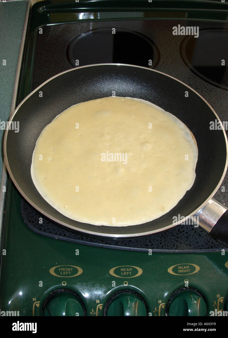Close up of cooking pancakes on a hotplate using a frying pan Stock Photo