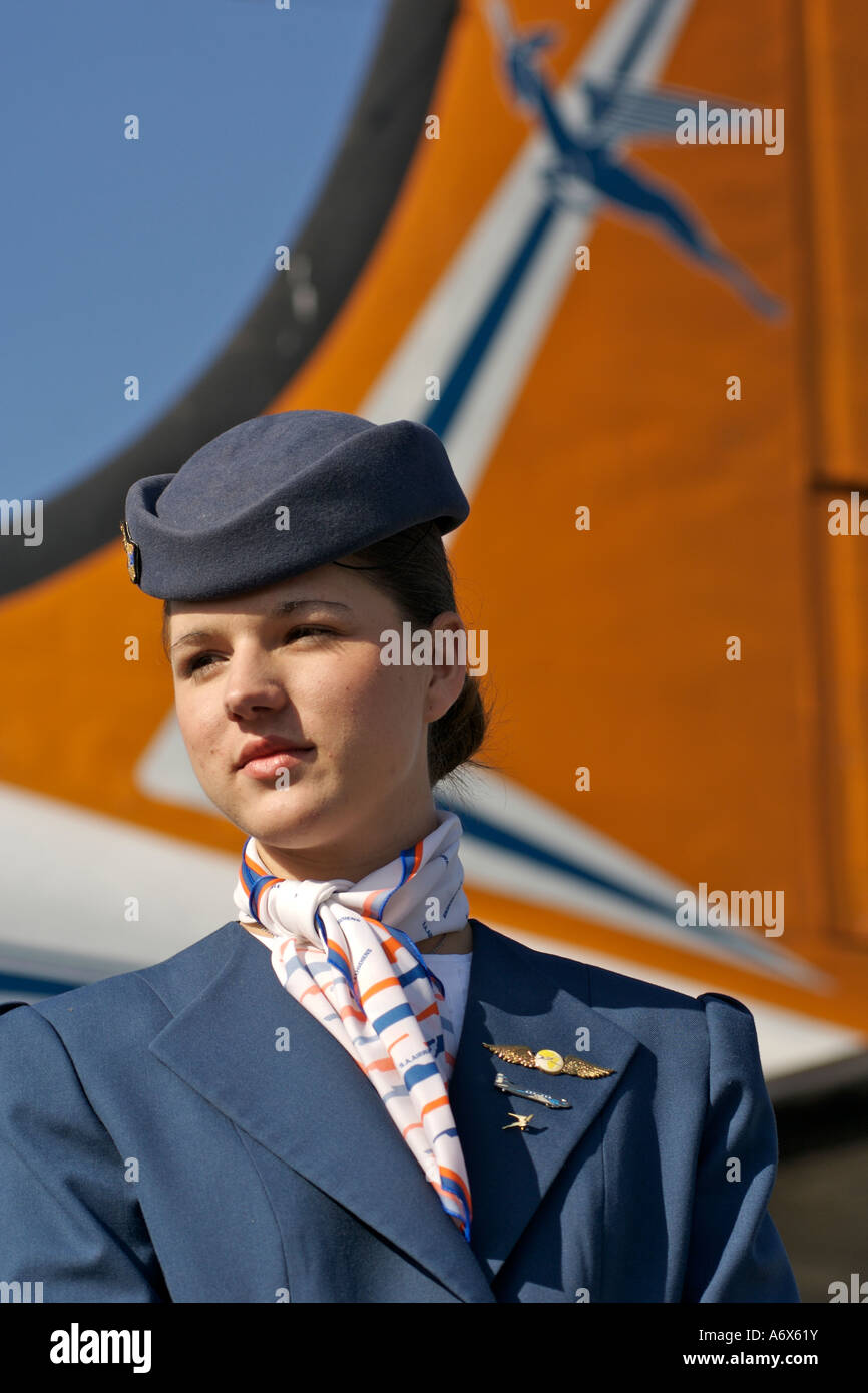 Air hostess in traditional fifties uniform standing alongside an old South African Airways DC-4. Stock Photo