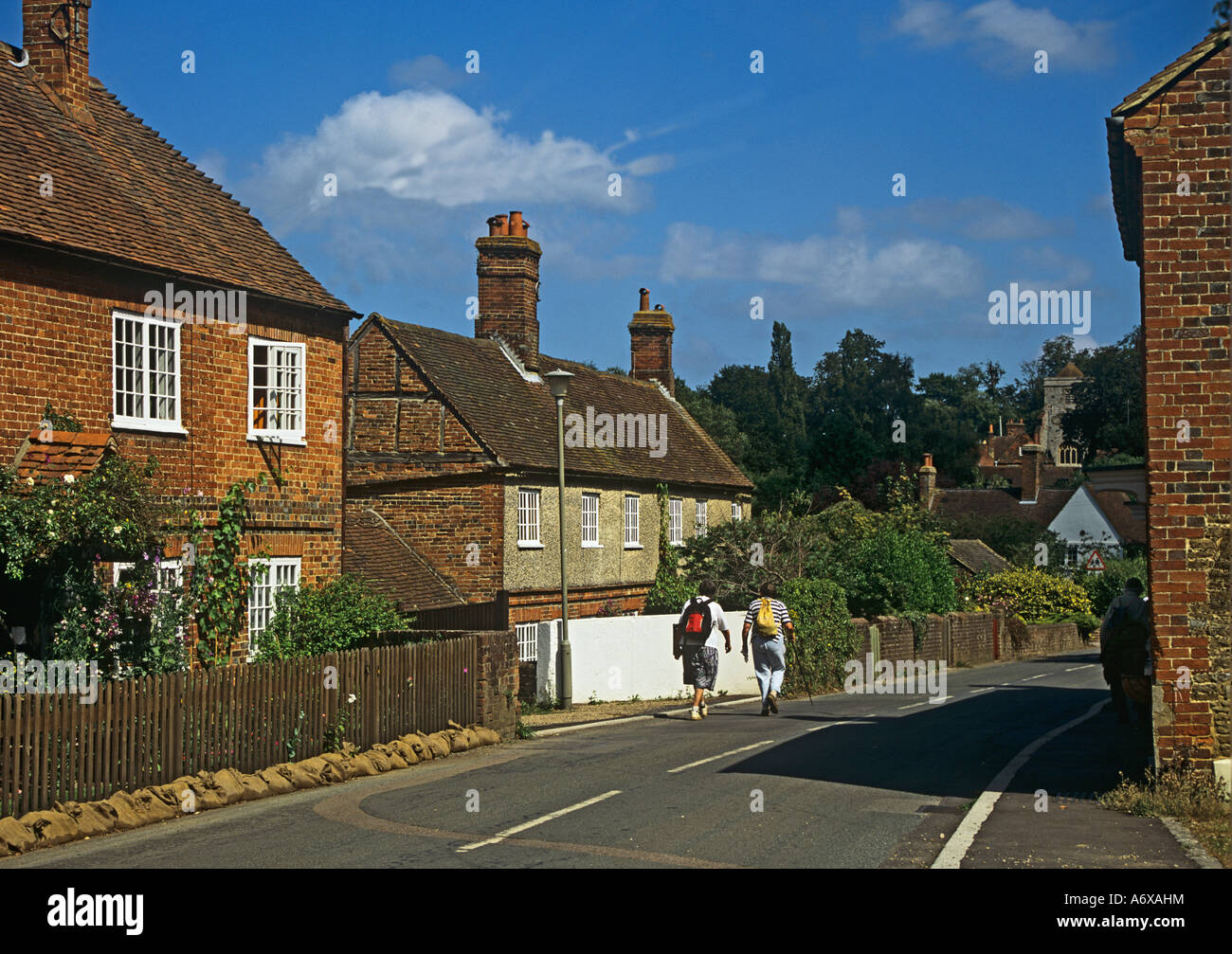 PUTTENHAM SURREY UK August Male and female ramblers walking down the main street of this picturesque village Stock Photo