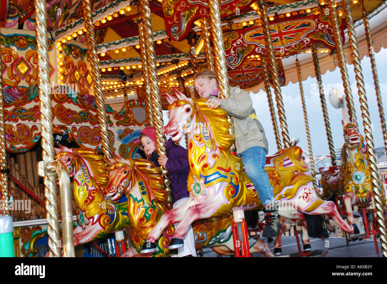 children on a funfair horse ride brighton pier south coast england Stock Photo