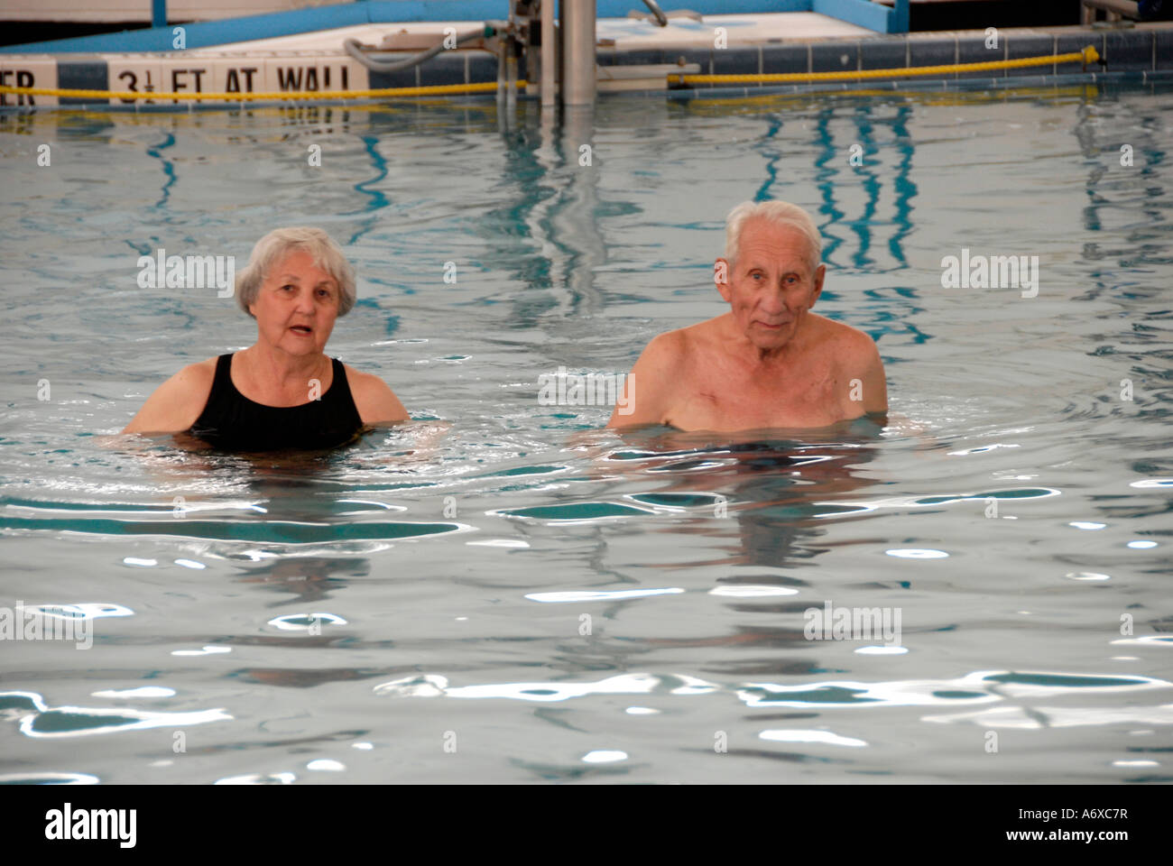 Senior citizens exercise in a swimming pool by walking a set number of