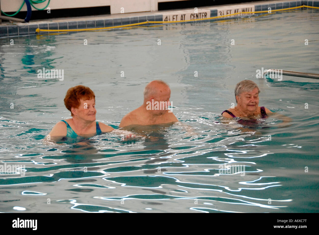 Senior citizens exercise in a swimming pool by walking a set number of
