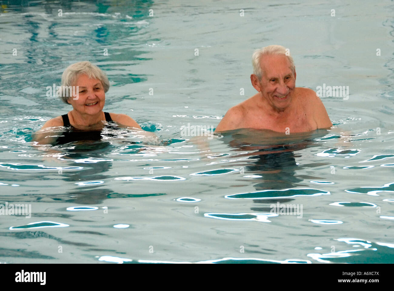 Senior citizens exercise in a swimming pool by walking a set number of