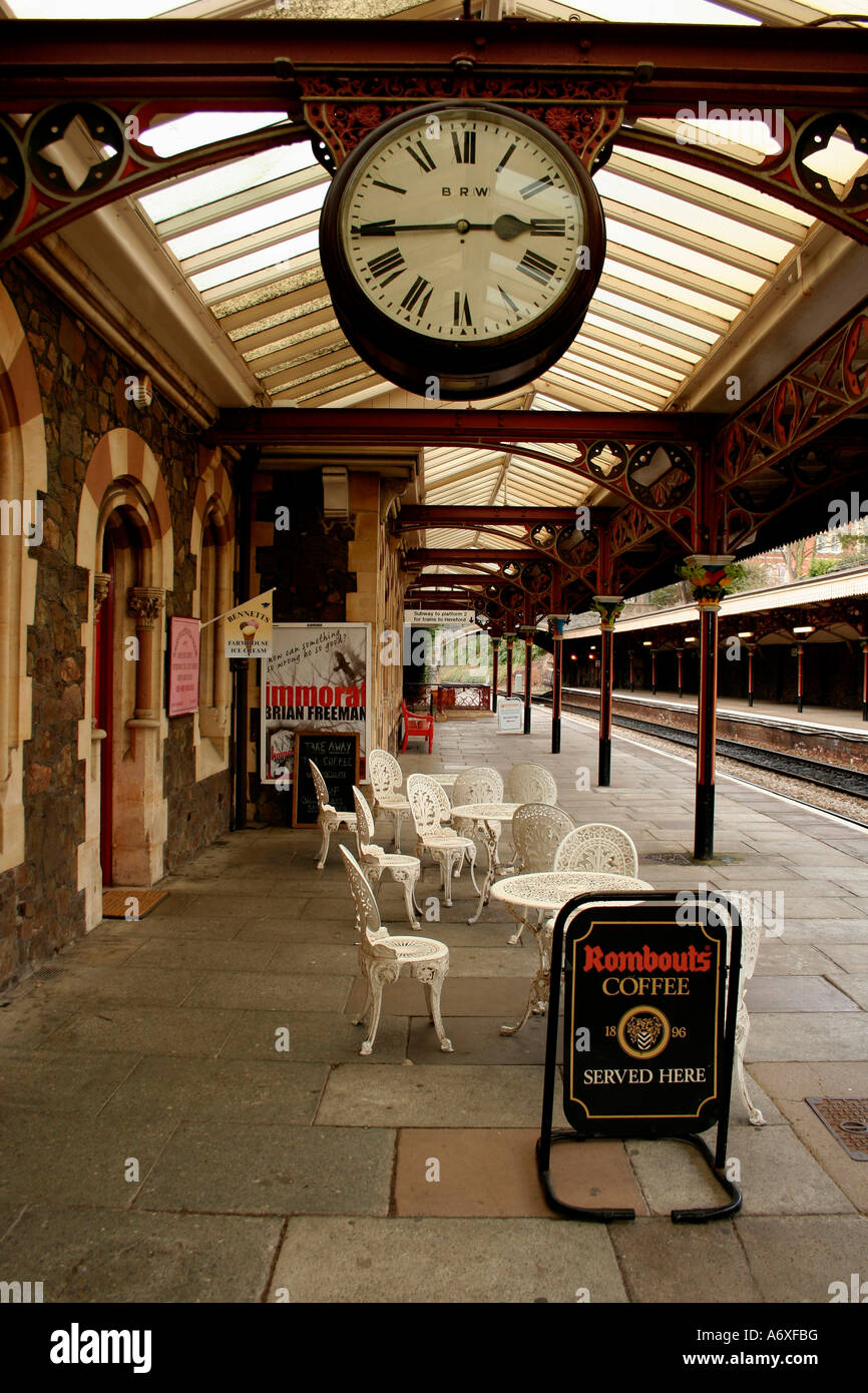 clock and cafe chairs on the platform of great malvern train station