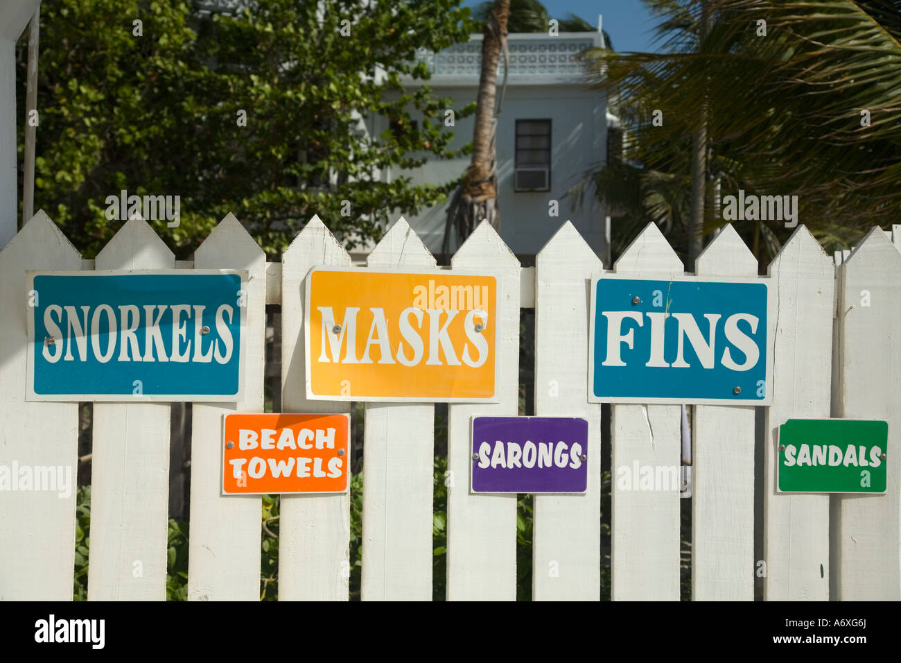 BELIZE San Pedro on Ambergris Caye Signs for snorkels masks fins beach towels on white picket fence outside store Stock Photo