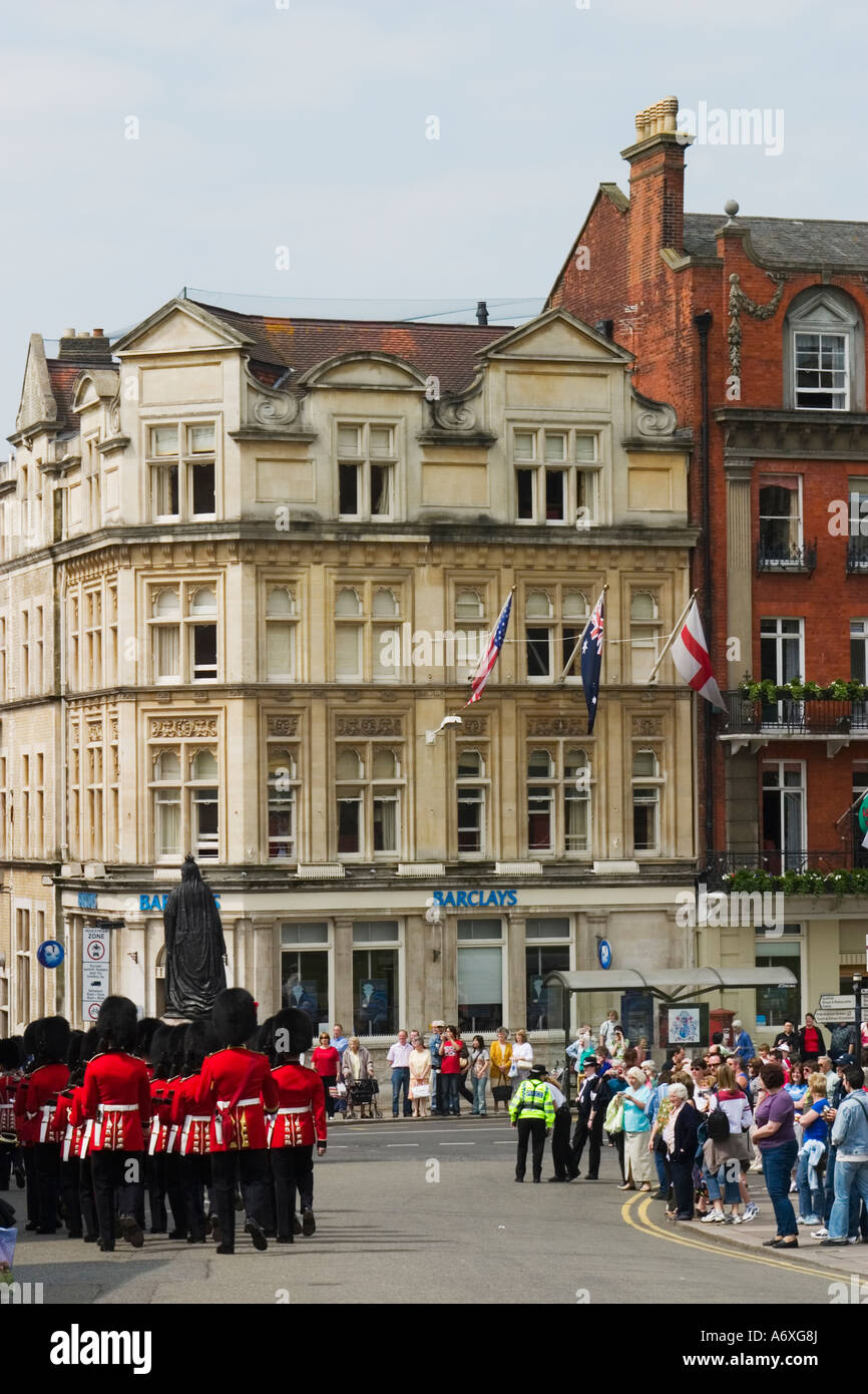 ENGLAND Windsor Changing of the Queens guard marching down street red coats and uniforms tourists stand on sidewalk Stock Photo