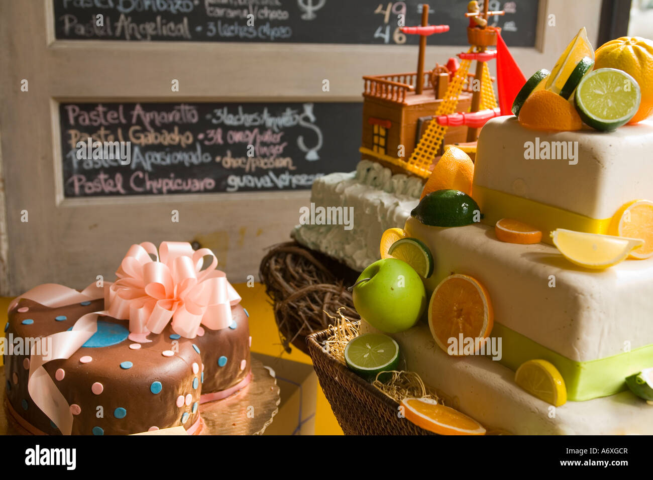 ILLINOIS Chicago Decorated cakes in bakery store window in Pilsen neighborhood prices on chalkboard Stock Photo