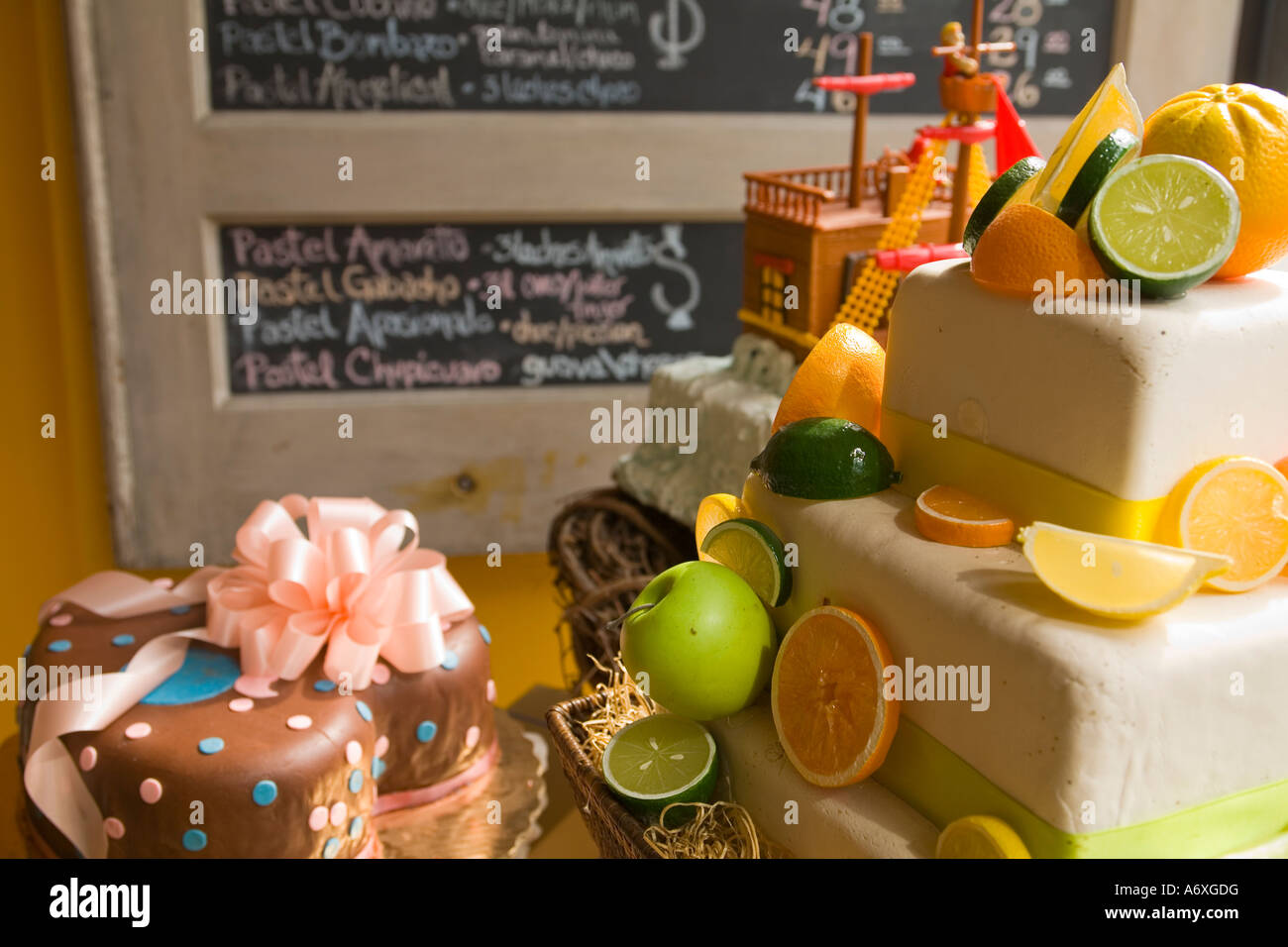 ILLINOIS Chicago Decorated cakes in bakery store window in Pilsen neighborhood prices on chalkboard Stock Photo