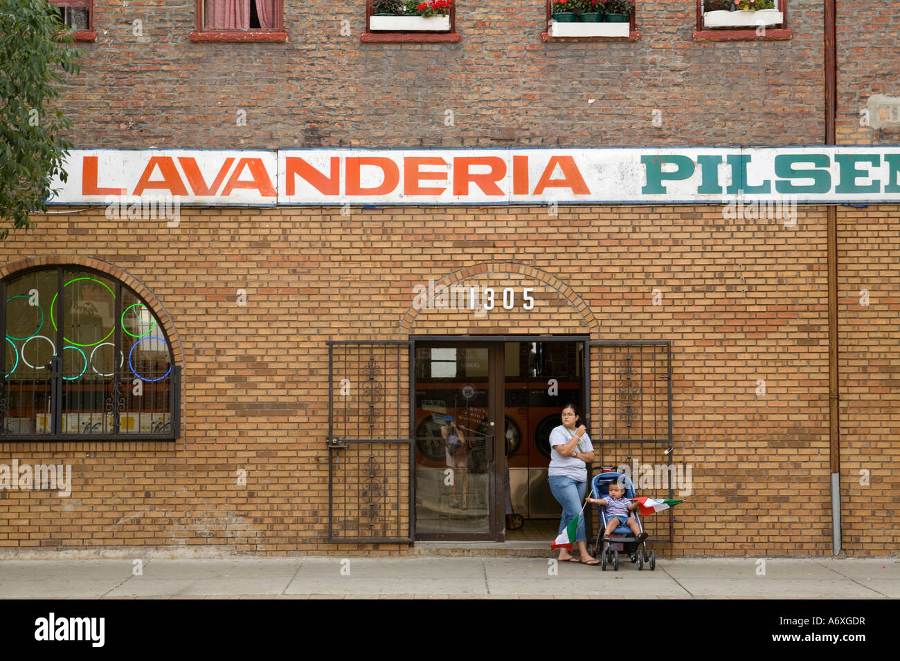ILLINOIS Chicago Young boy in stroller hold Mexican flags woman stand