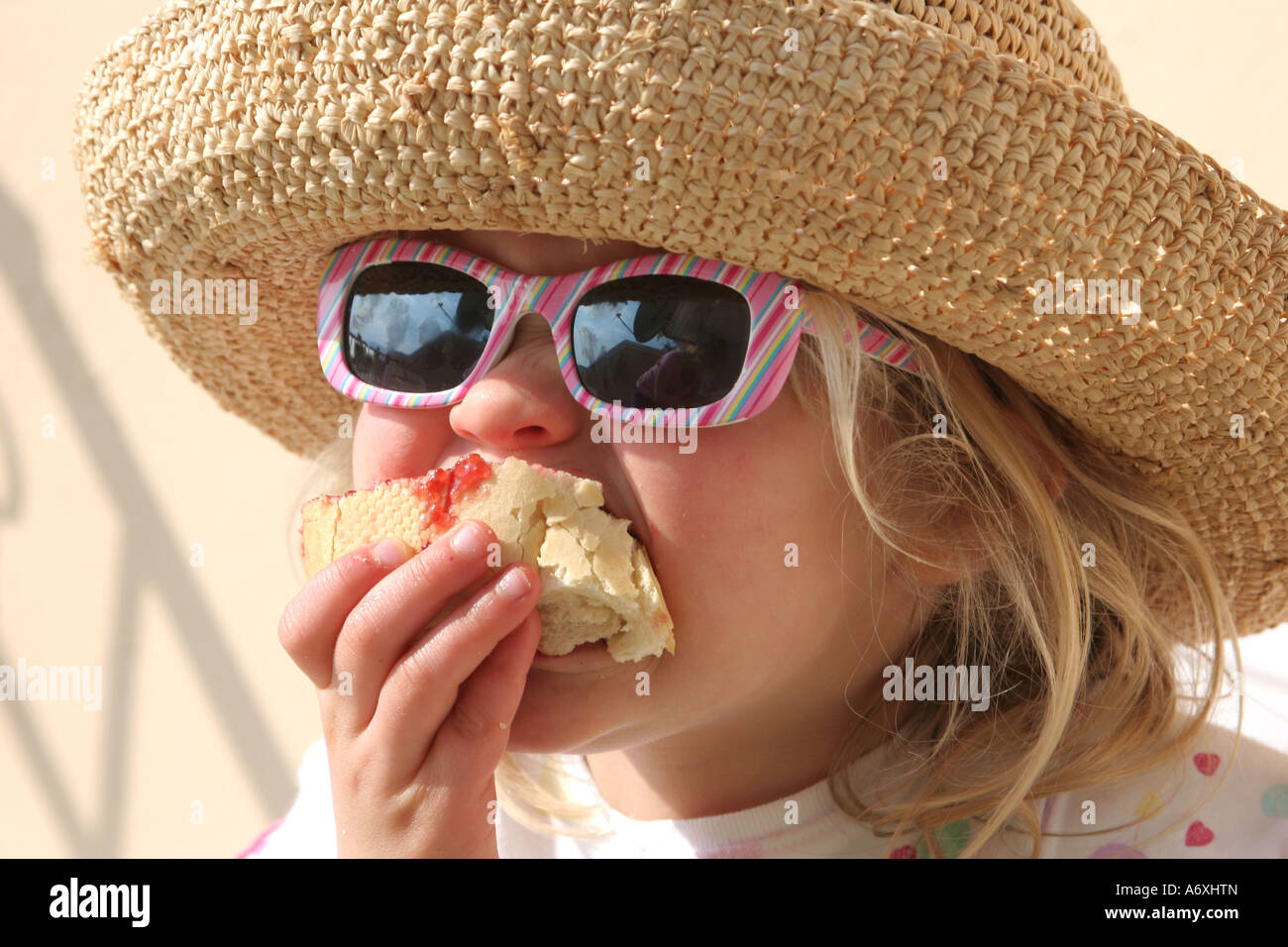 young girl eating jam roll Stock Photo Alamy