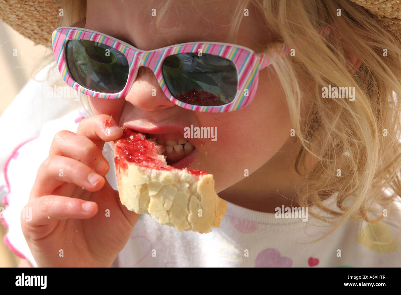 young girl eating jam roll Stock Photo Alamy