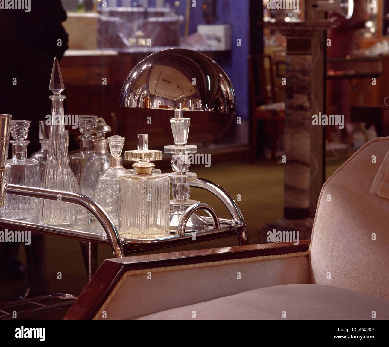 Close-up of chrome trolley with Thirties glass+chrome lamp and collection of glass decanters Stock Photo