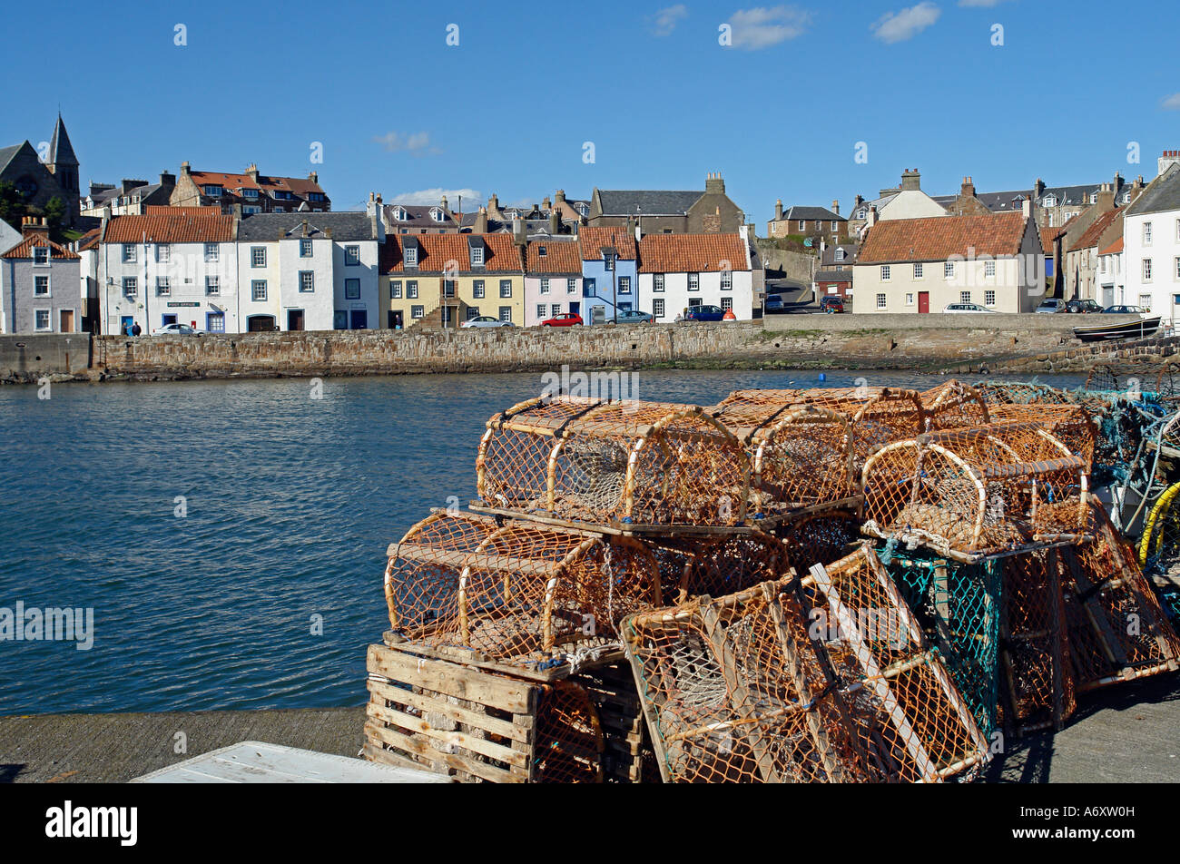 Fishing gear on a pier in St. Monans harbour in Fife Scotland with traditional colourful houses in the background. Stock Photo