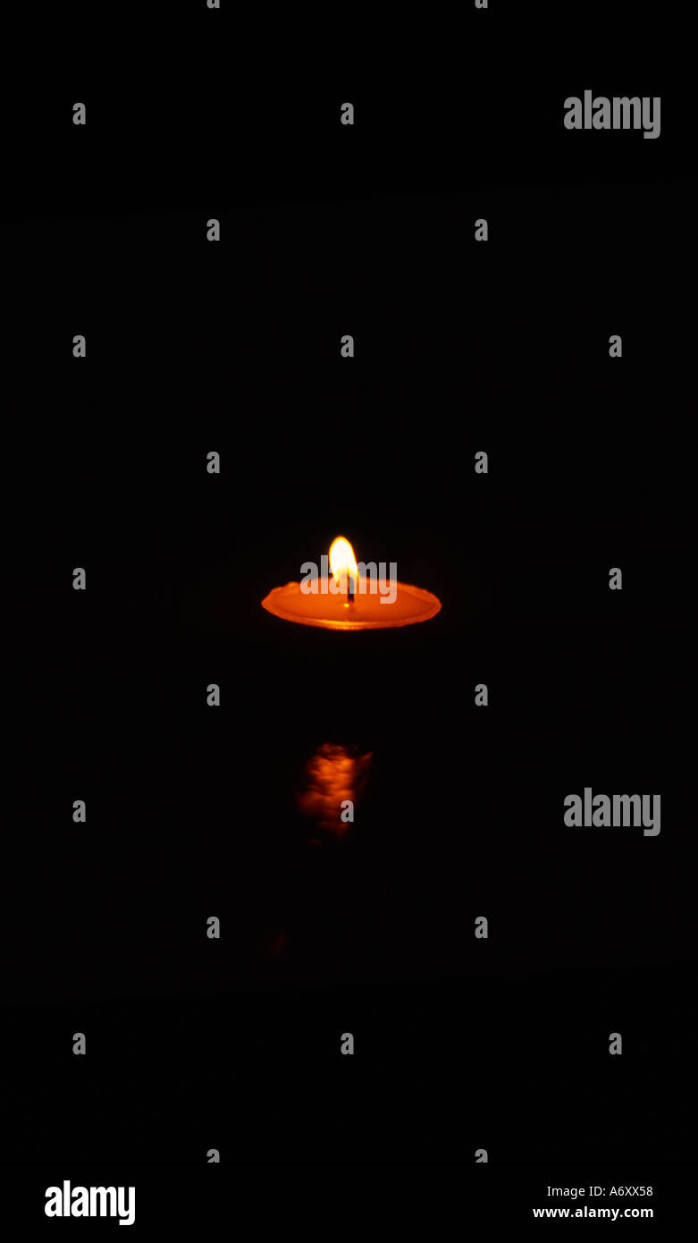 One Small candle in night Stock Photo