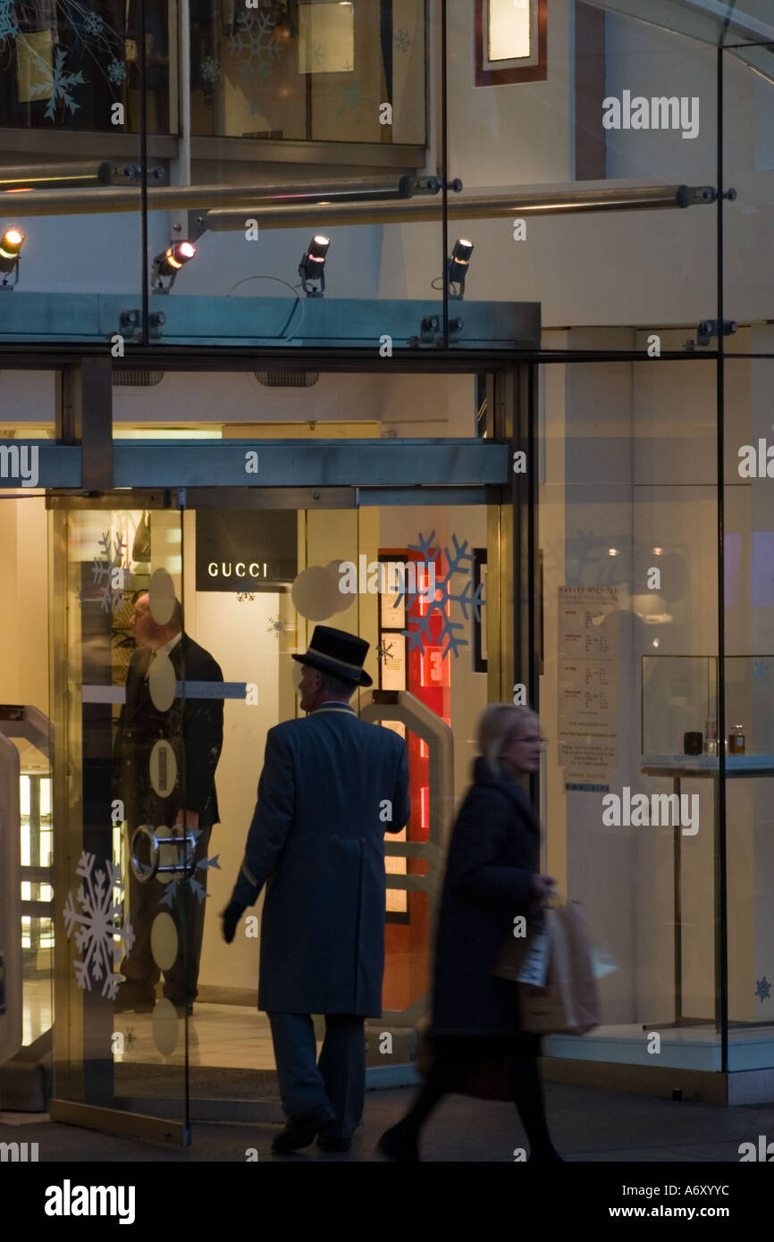 Evening view of entrance to Harvey Nichols Briggate Leeds with commissionaire in top hat. Stock Photo